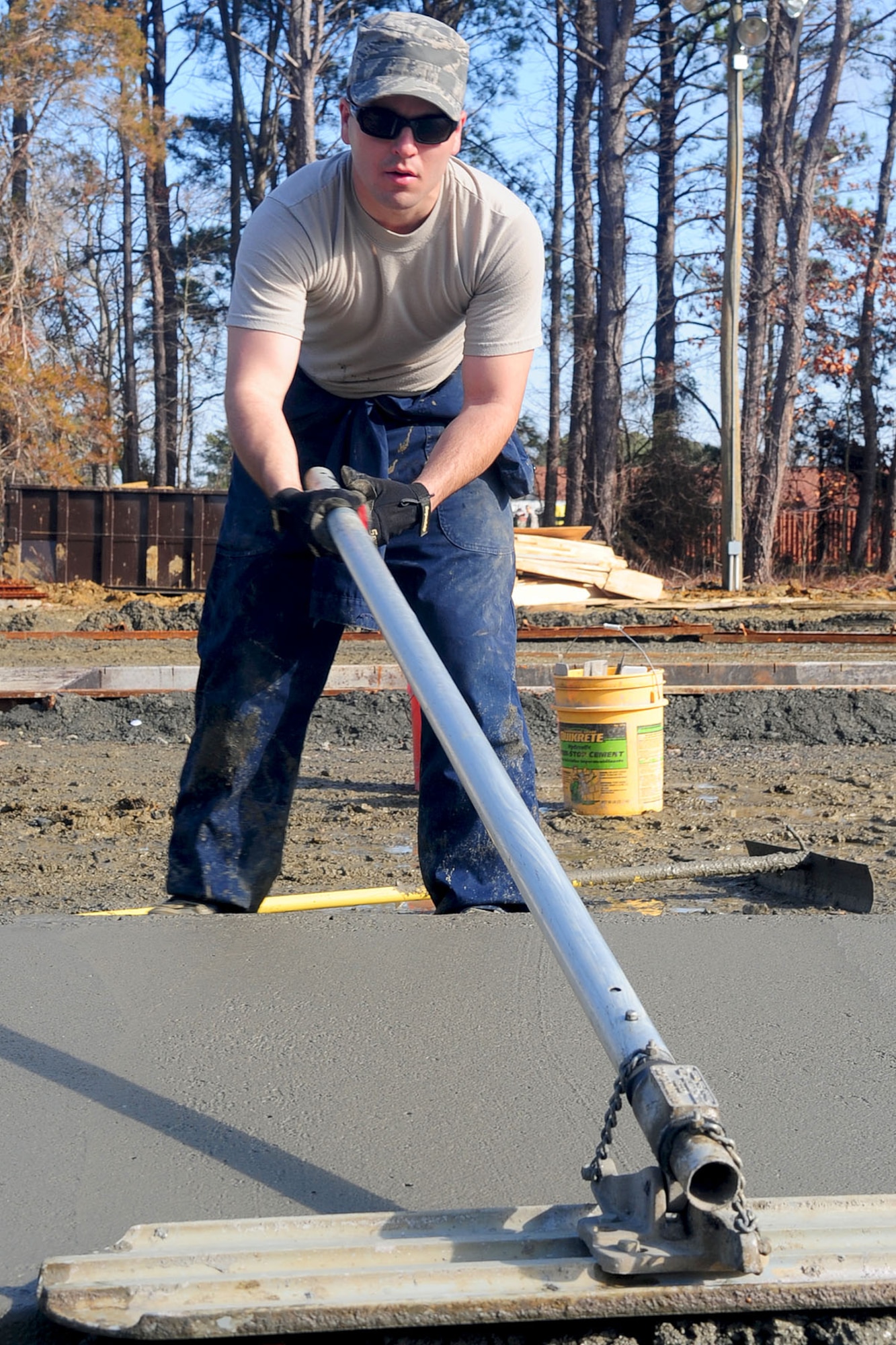U.S. Air Force Staff Sgt. Christopher Stoeckle, 633rd Civil Engineer Squadron heavy equipment operator, levels cement with a bull float at Langley Air Force Base, Va., Jan. 24, 2012. The 633rd CES aims to complete construction of the new Raptor Town prior to an upcoming operational readiness exercise. (U.S. Air Force photo by Staff Sgt. Ashley Hawkins/Released)