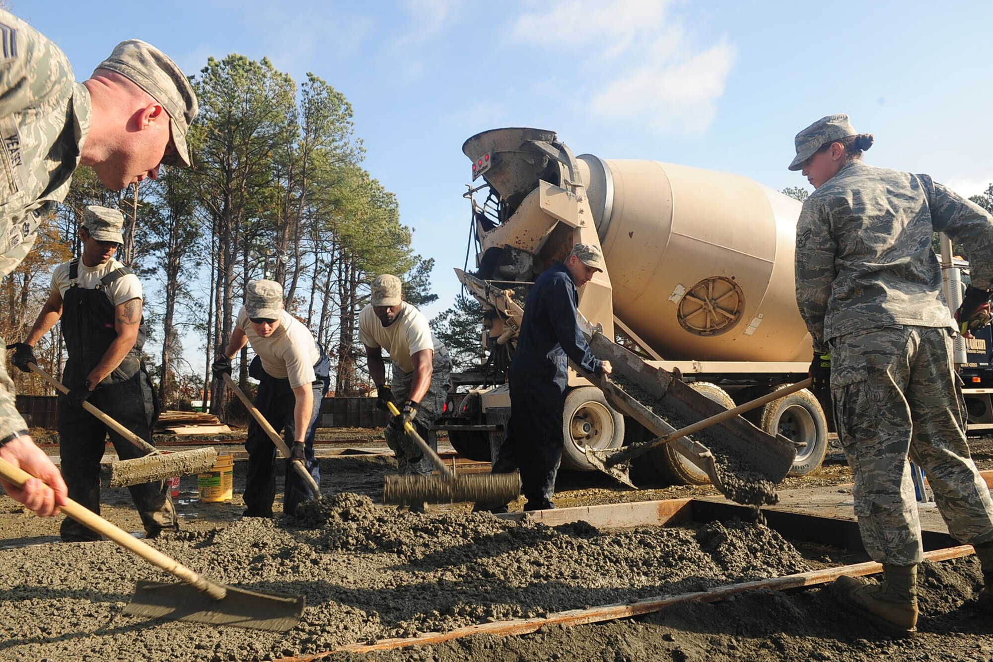Members of the 633rd Civil Engineer Squadron pour and level cement at Langley Air Force Base Va., Jan. 24, 2012. Members of the 633rd CES, including leadership, worked together the last week of January, aiming to complete the Raptor Town project one year ahead of schedule. (U.S. Air Force photo by Staff Sgt. Ashley Hawkins/Released)