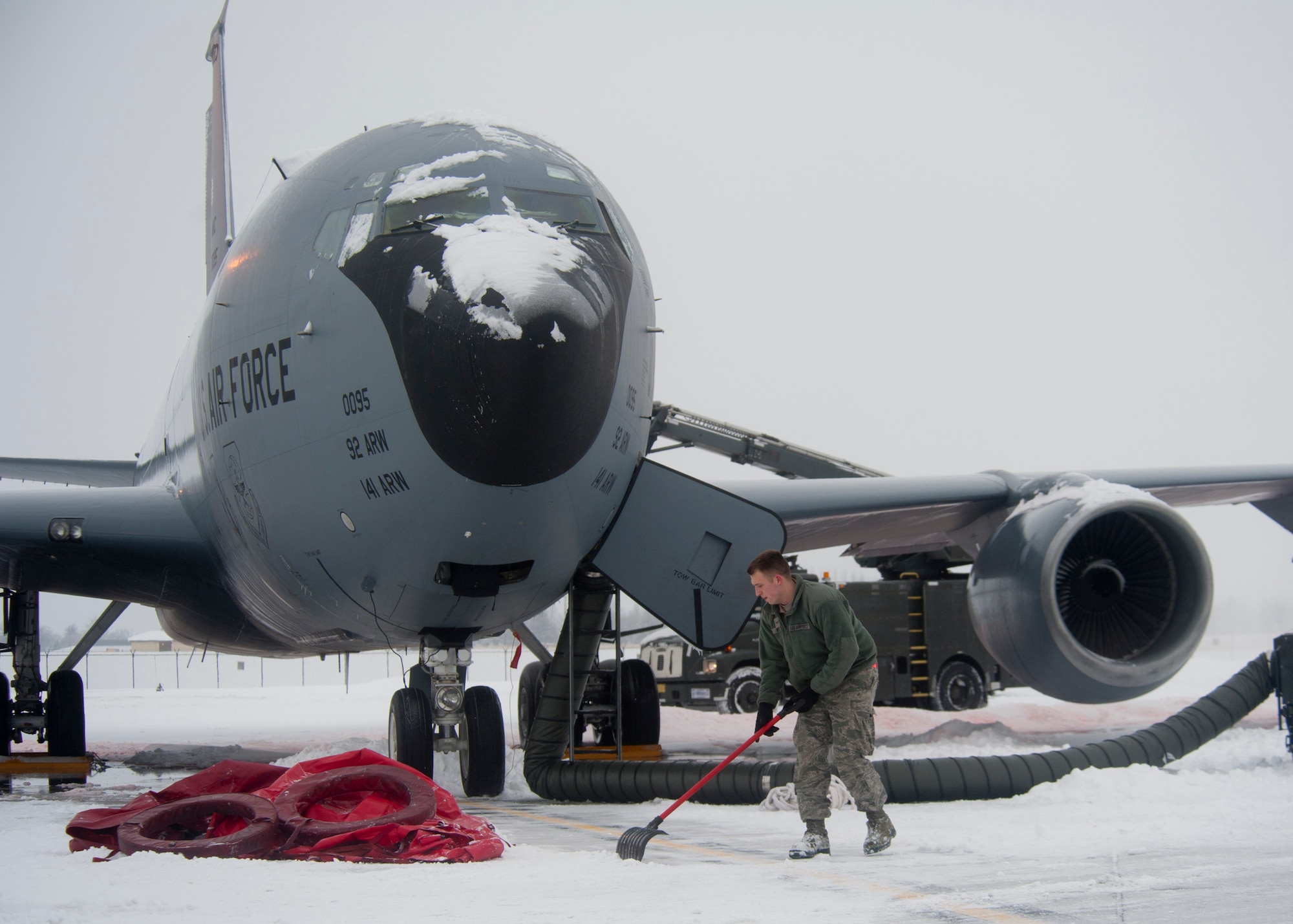 Airman 1st Class Christopher Ayoub, 92nd Aircraft Maintenance Squadron, removes snow from around a KC-135 Stratotanker refueling aircraft at Fairchild Air Force Base, Wash., Jan. 20, 2012. (U.S. Air Force photo by Staff Sgt. Michael Means)