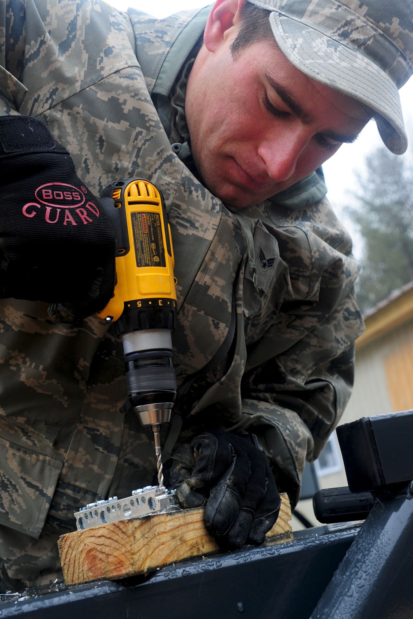 U.S. Air Force Senior Airman Sean Alberts, 633rd Civil Engineer Squadron, electrical apprentice, drills holes into a bus bar before screwing it into an electric panel at Langley Air Force Base, Va., Jan. 23, 2012. The buildings in the newly renovated Raptor Town will be equipped with electricity, heating and air conditioning. (U.S. Air Force photo by Staff Sgt. Ashley Hawkins/Released)
