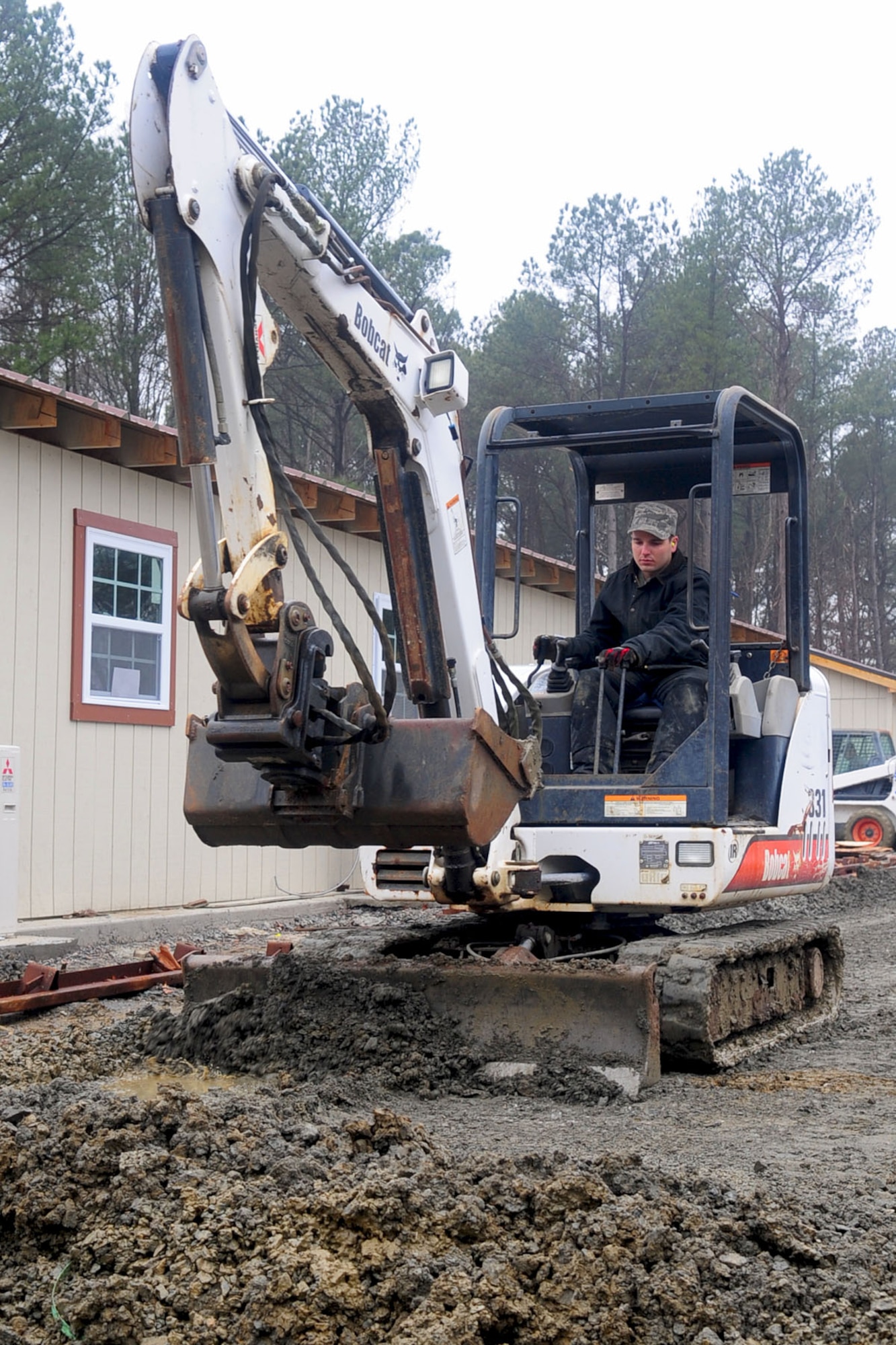 U.S. Air Force Staff Sgt. Christopher Stoeckle, 633rd Civil Engineer Squadron heavy equipment operator, levels the ground at the Raptor Town construction site, at Langley Air Force Base, Va., Jan., 23, 2012. Members of the 633rd CES are rebuilding the training site to serve as a simulated deployed location. (U.S. Air Force photo by Staff Sgt. Ashley Hawkins/Released)