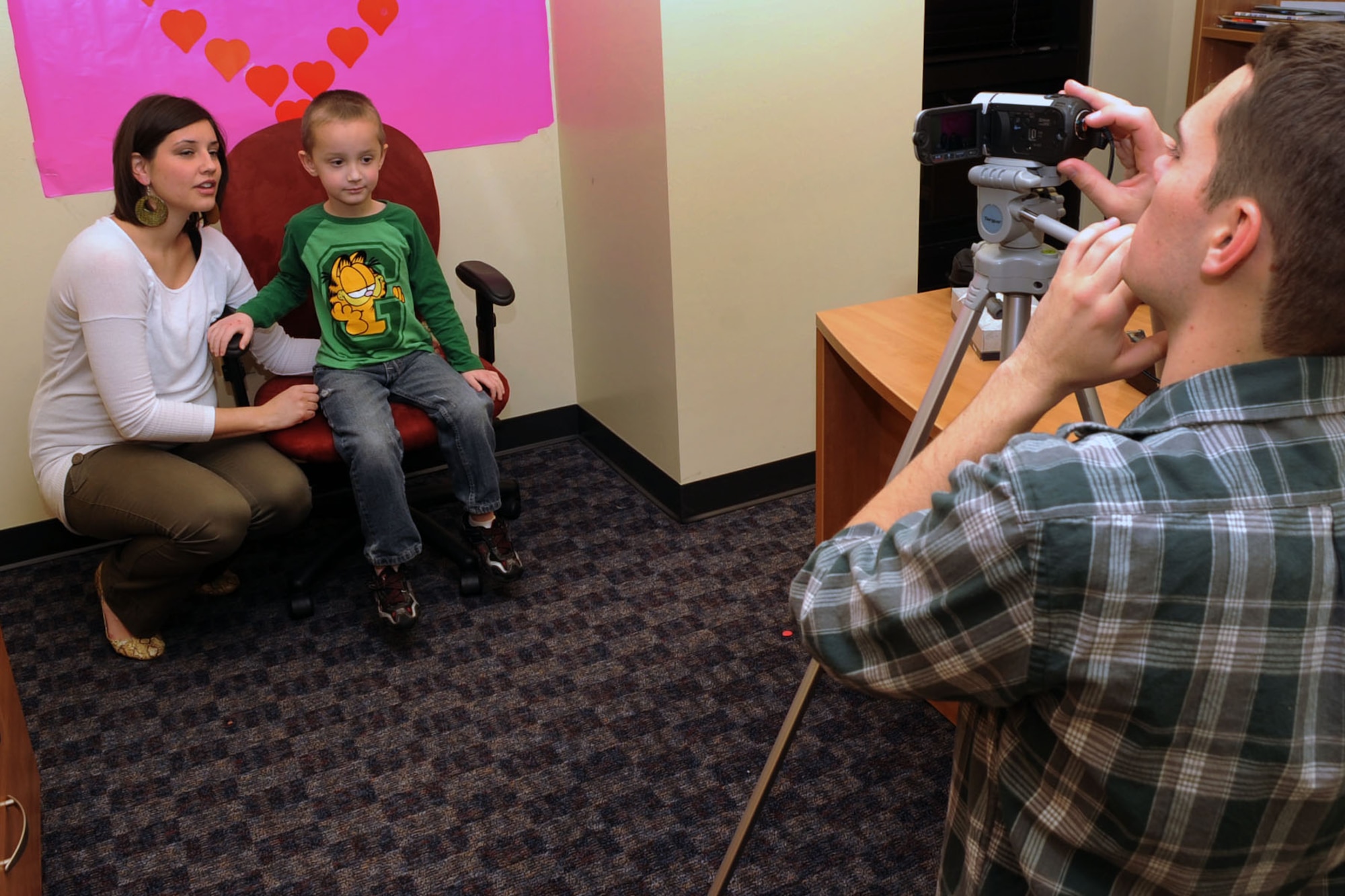 Shannon Misiniec helps her son, Christian, make a Valentine’s Day Video message for her husband, U.S. Air Force Airman 1st Class Lukasz Misiniec, during the “Hearts Apart” event at Langley Air Force Base, Va., Jan. 20, 2012.The event included creating cards, and recording video messages to send to deployed 
loved ones. (U.S. Air Force photo by Staff Sgt. Jeff Nevison/Released)  
