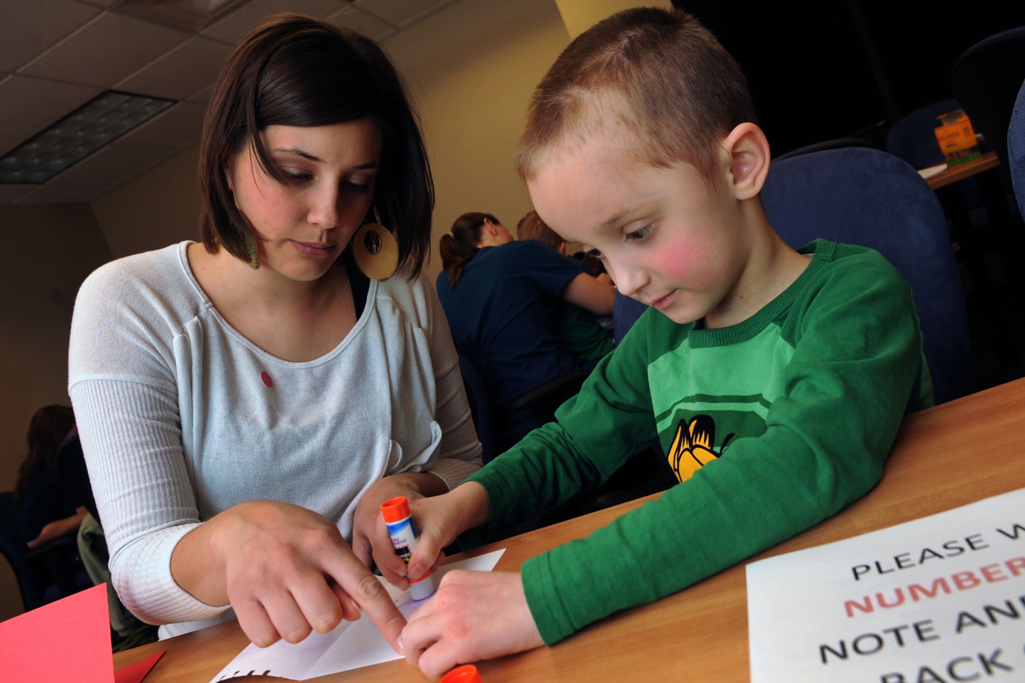 Shannon Misiniec helps her son, Christian, make a Valentine’s Day card for her deployed 
husband, U.S. Air Force Airman 1st Class Lukasz Misiniec, at Langley Air Force Base, Va., Jan. 20, 2012. 
Approximately 40 families signed up for the “Hearts Apart” event that included creating cards, recording video messages to send to deployed loved ones, and giving pizza and snacks to the children. (U.S. Air Force photo by Staff Sgt. Jeff Nevison/Released)  
