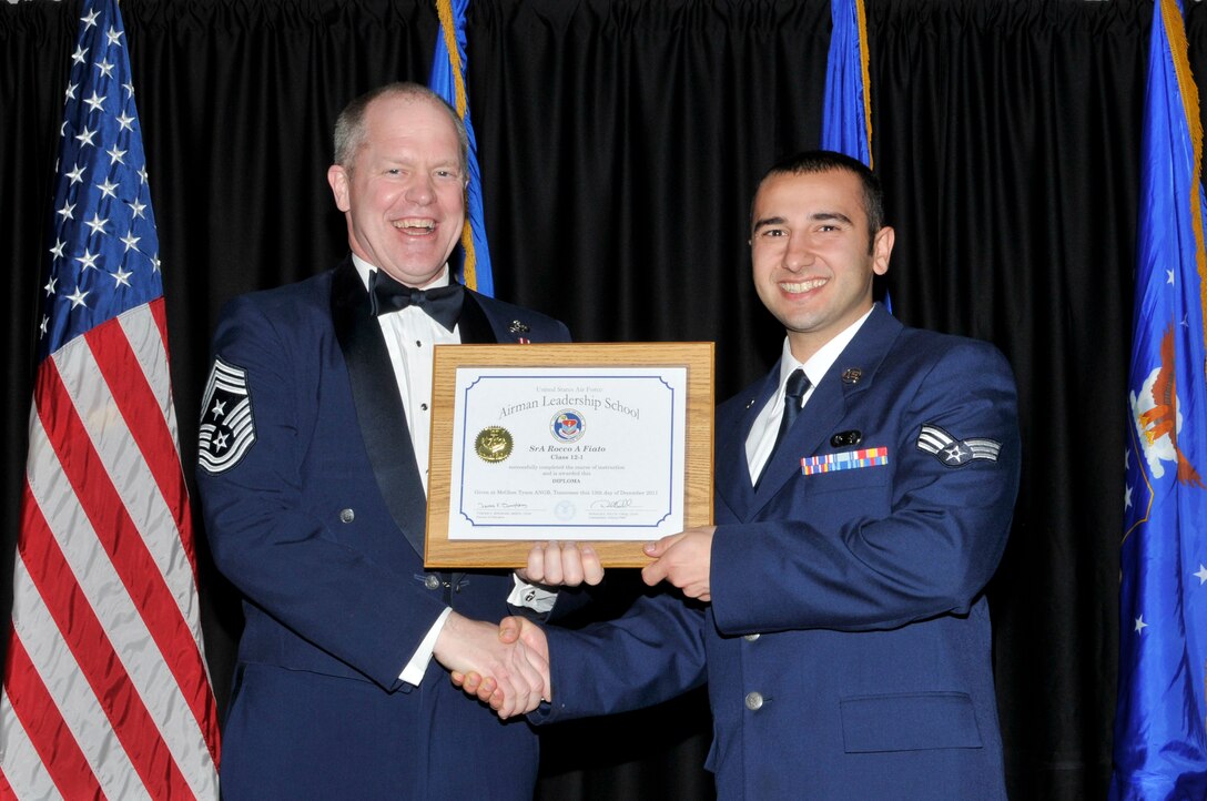 McGHEE TYSON AIR NATIONAL GUARD BASE, Tenn. - Senior Airman Rocco A. Fiato, right, receives the distinguished graduate award for Airman Leadership School Class 12-1, at The I.G. Brown Air National Guard Training and Education Center from the Air National Guard Command Chief Master Sgt. Christopher E. Muncy, Dec. 13, 2011.  The distinguished graduate award is presented to students in the top ten percent of the class.  It is based on objective and performance evaluations, demonstrated leadership, and performance as a team player. (U.S. Air Force photo by Master Sgt. Kurt Skoglund/Released)