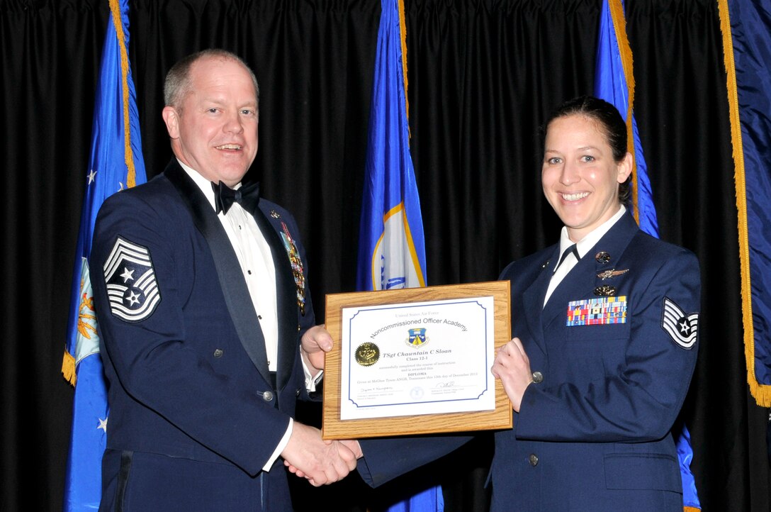 McGHEE TYSON AIR NATIONAL GUARD BASE, Tenn. - Tech. Sgt. Chawntain C. Sloan, right, receives the distinguished graduate award for Satellite NCO Academy Class 12-1 at The I.G. Brown Air National Guard Training and Education Center from Air National Guard Command Chief Master Sgt. Christopher E. Muncy, Dec. 13, 2011. The distinguished graduate award is presented to students in the top ten percent of the class.  It is based on objective and performance evaluations, demonstrated leadership, and performance as a team player. (U.S. Air Force photo by Master Sgt. Kurt Skoglund/Released)