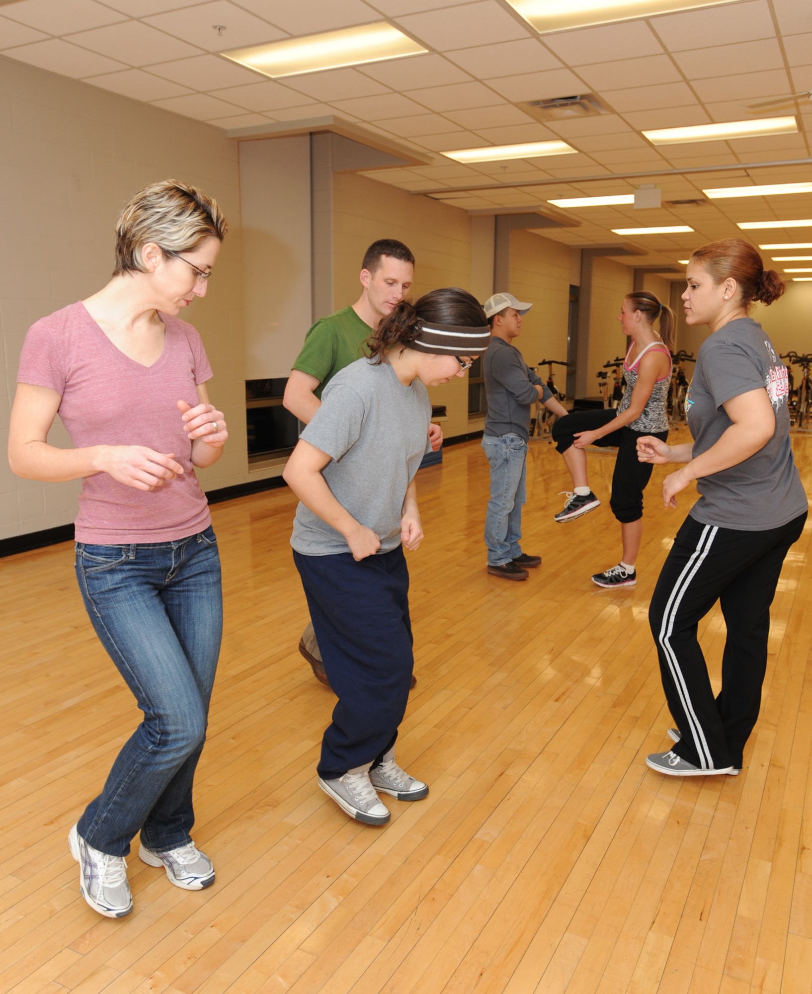 MINOT AIR FORCE BASE, N.D. -- (Center) Airman 1st Class Camille Berio, 5th Aircraft Maintenance Squadron aerospace propulsion technician and Latin dance instructor, explains to students the proper leg movements for dancing Salsa, during a night of Latin dance lessons at the McAdoo Sports and Fitness Center Jan 23. Classes like these offer Airmen and their families the opportunity to go out and experience new activities, especially during the cold winter months in Minot. Free Latin dance lessons are offered at the Fitness Center every Monday and Thursday from 8-9 p.m. Individuals wanting to learn how to dance popular Latin American music genres to include Bachata, Merengue, and Salsa are welcome to attend. (U.S. Air Force photo/Senior Airman Jose L. Hernandez)