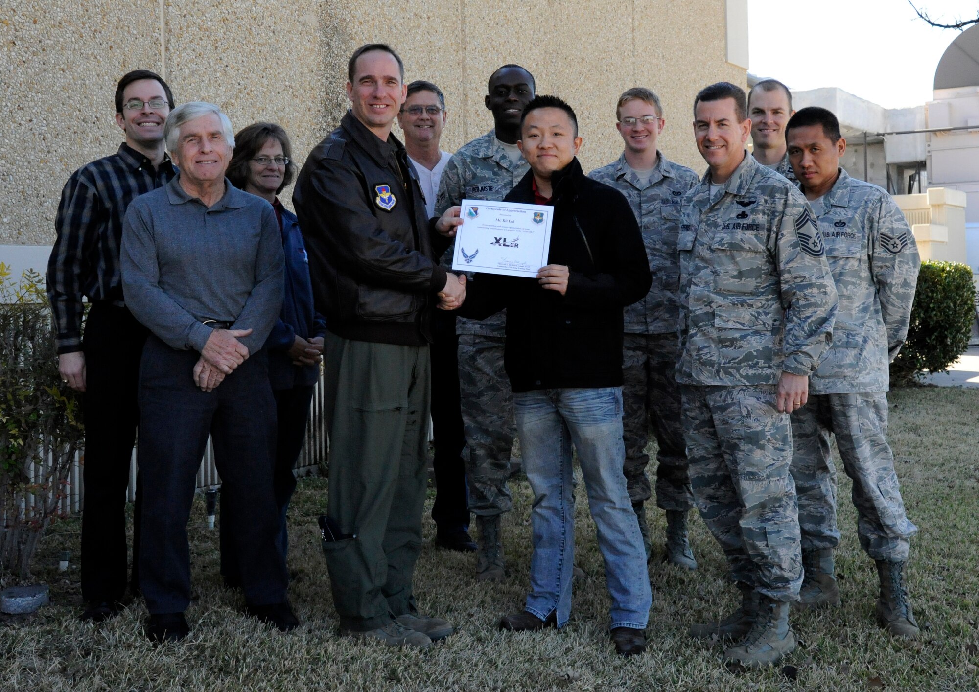 LAUGHLIN AIR FORCE BASE, Texas – Kit Lui, 47th Civil Engineering Squadron construction control inspector, poses with Col. Tom Murphy, 47th Flying Training Wing commander, and Chief Master Sgt. Dean Ferris, 47th Operations Group superintendant, after being presented the XLer of the week award here Jan. 11. The XLer is a weekly award chosen by wing leadership and given to those who consistently make outstanding contributions to Laughlin and their unit. (U.S. Air Force photo/Airman 1st Class Nathan L. Maysonet)