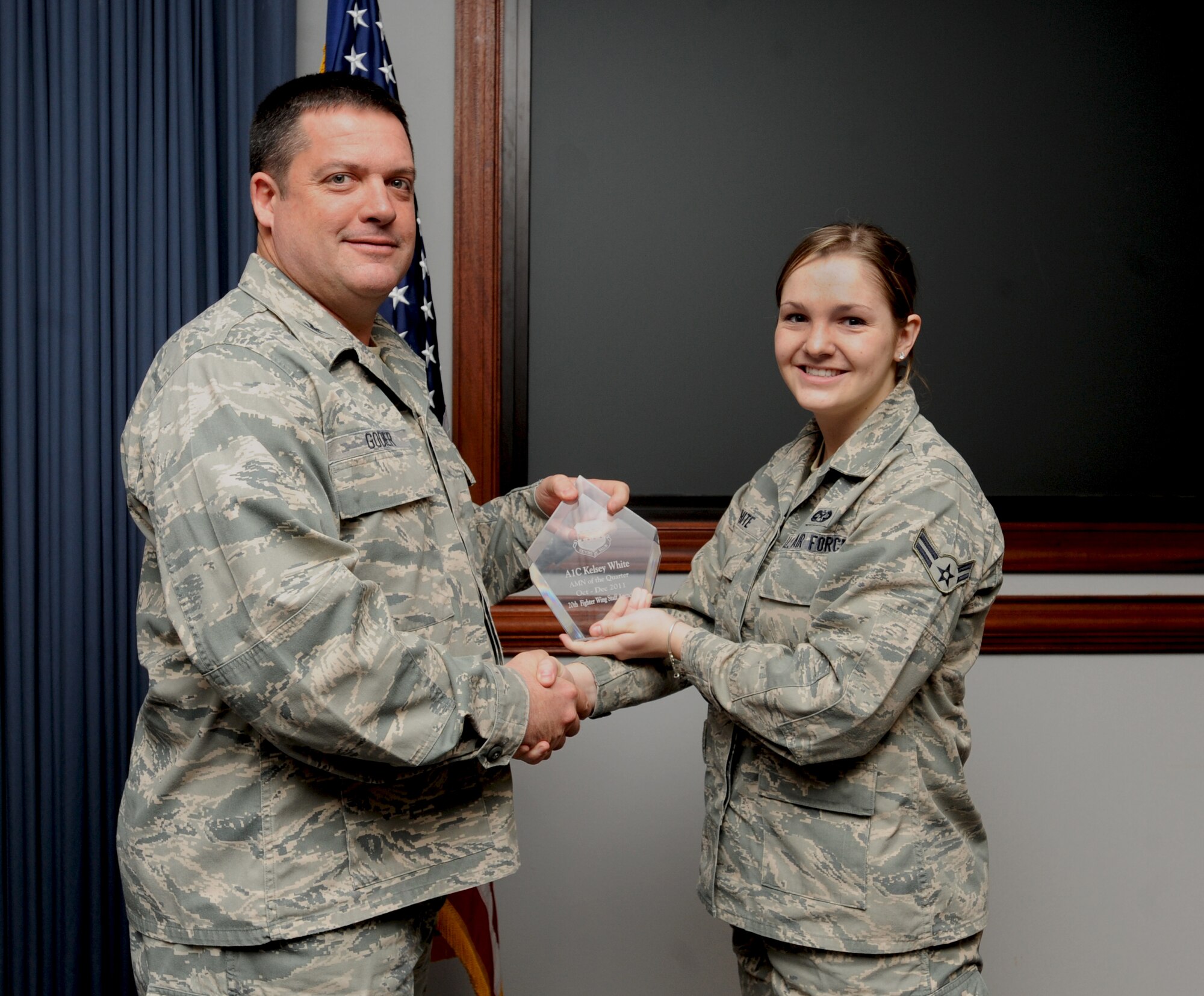 U.S. Air Force Col. Don Godier, 20th Fighter Wing vice commander, gives Airman 1st Class Kelsey White, 20th Fighter Wing Legal Office military justice paralegal, the Airman of the Quarter Award, Shaw Air Force Base, S.C., Jan. 20, 2012. White is the Warrior of the Week for Jan. 23 to 26. (U.S. Air Force photo by Airman 1st Class Tabatha McCarthy/Released)
