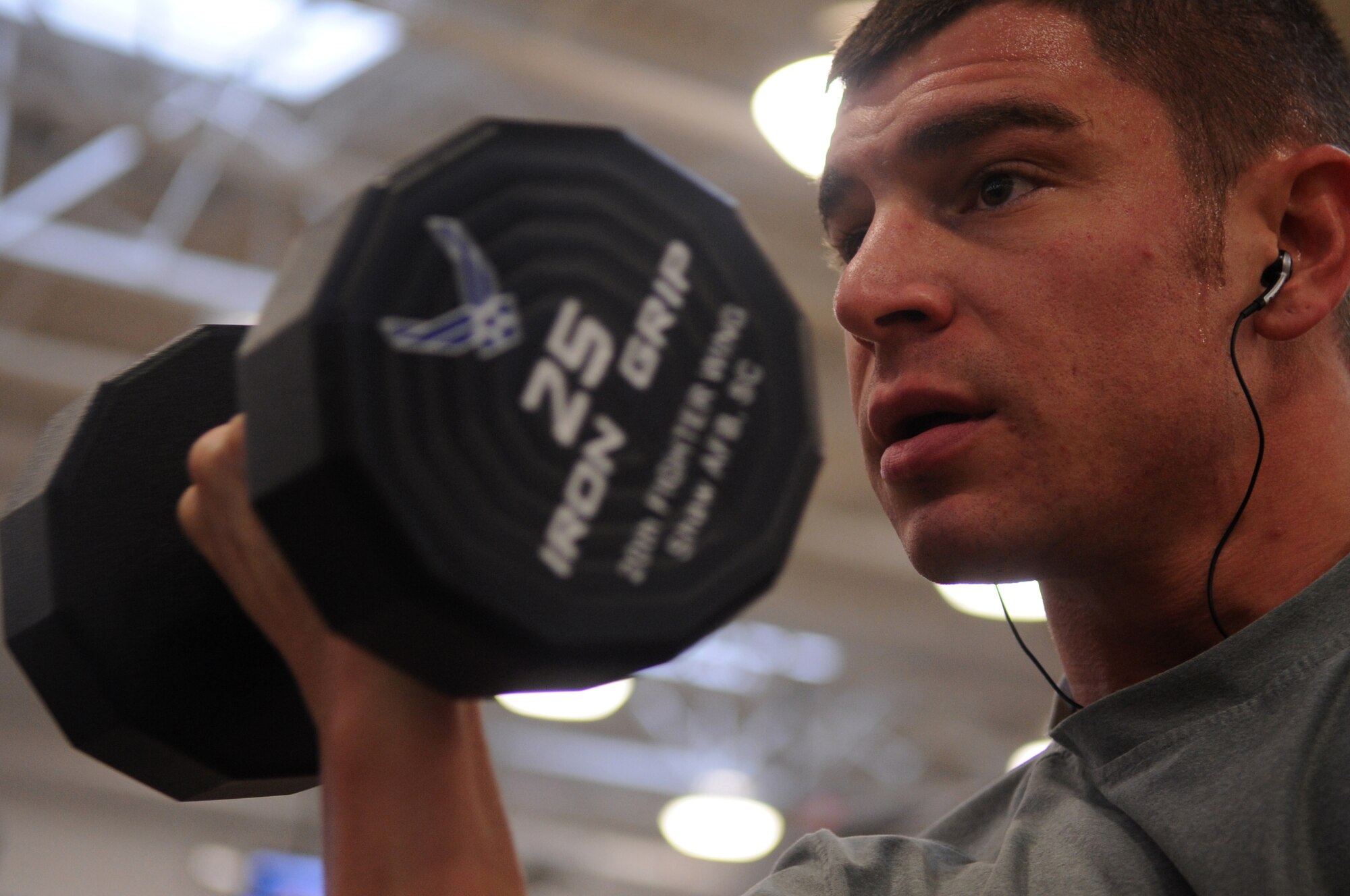 U.S. Air Force Tech. Sgt. Andrew Dicarlo, 20th Operations Support Squadron air traffic controller watch supervisor/RAPCON, focuses on his alternate curl exercise at the fitness center, Shaw Air Force Base, S.C., Jan. 24, 2012. Shaw Airmen use the fitness center daily to keep up their physical fitness ensuring they are prepared for deployment. (U.S. Air Force photo by Airman First Class Hunter Brady/Released)