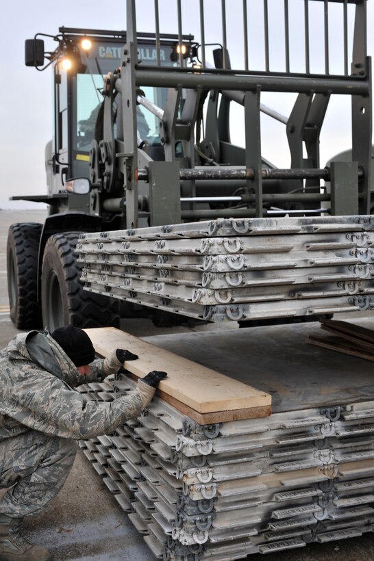 Senior Airman Mario Ortiz Jr., 435th Contingency Response Group crew chief, helps stack pallets while on location in Constanta, Romania, Jan. 19, 2012. The 435th CRG unloaded more than 100 pallets worth of equipment during their temporary duty assignment. (U.S. Air Force photo by Airman 1st Class Caitlin O'Neil-McKeown)
