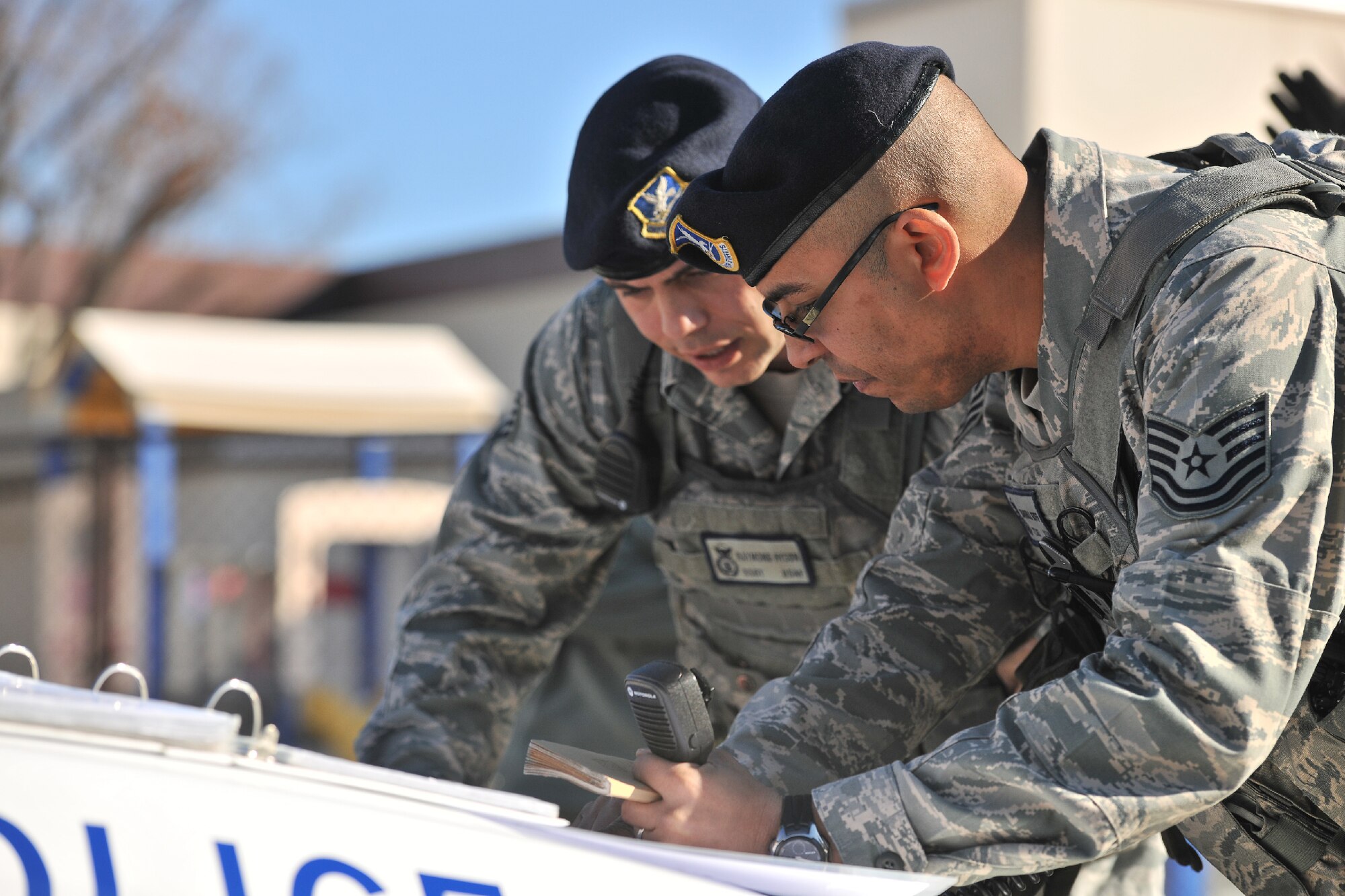 YOKOTA AIR BASE, Japan -- Tech. Sgt. Carrell Goff (right), 374th Security Forces Squadron military working dog handler, gets a report from Staff Sgt. Raymond Hyson, 374th SFS patrol man, during an emergency management exercise at Yokota Air Base, Japan, Jan. 25, 2012. Yokota airmen maintain operational readiness capabilities. (U.S. Air Force photo/Osakabe Yasuo)
