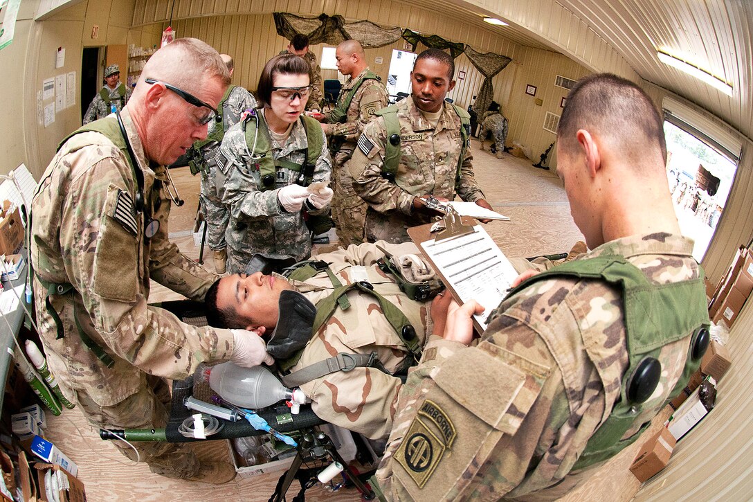 Army Sgt. Christopher Campbell, left, places a neck brace on a notionally-wounded paratrooper while Army Capt. Kate Kinnaird, center, and  Staff Sgt. Everet Anderson, right,
identify the rest of the patients wounds at the Joint Readiness Training Center, Fort Polk, La., Jan. 24, 2012. Campbell, Kinnaird and Anderson are assigned to the 82nd Airborne Division’s 1st Brigade Combat Team.