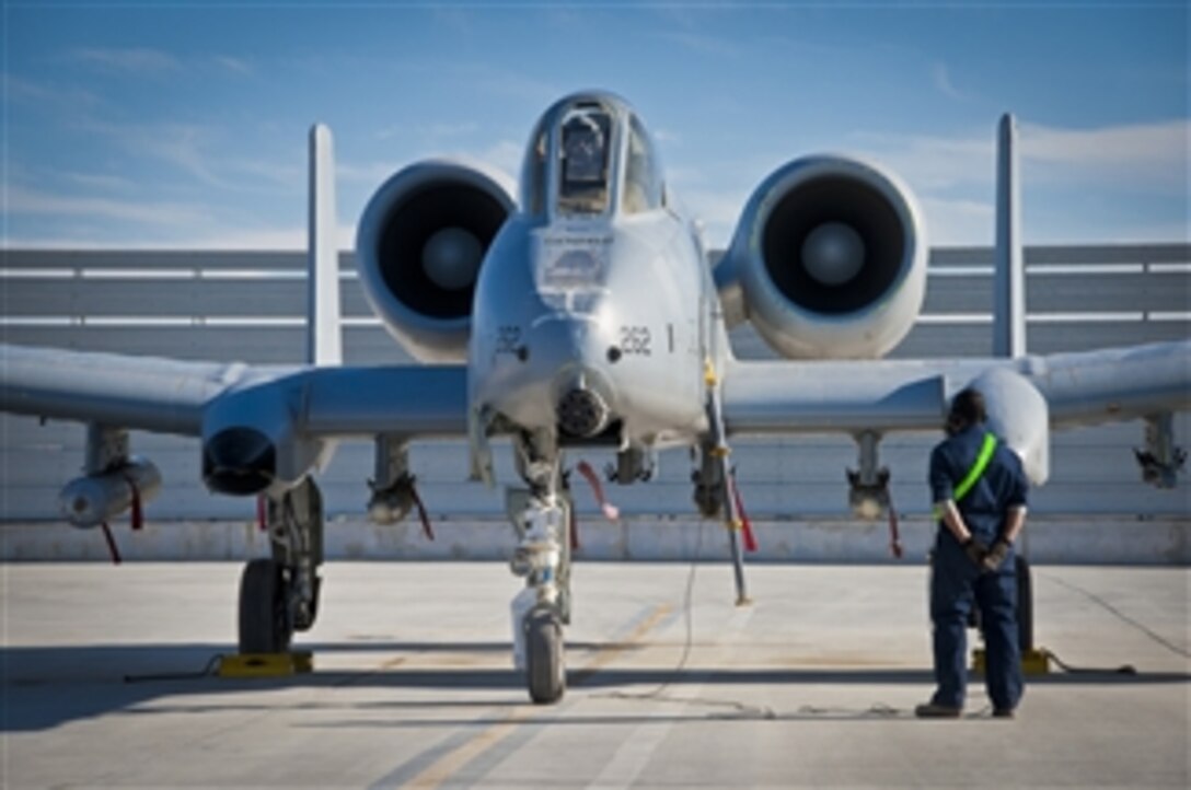 A 451st Expeditionary Aircraft Maintenance Squadron crew chief waits for the pilot's call to pull the chocks during an A-10 Thunderbolt II aircraft launch at Kandahar Airfield, Afghanistan, on Jan. 20, 2012.  The A-10 can employ a wide variety of conventional munitions, including general-purpose bombs, cluster bomb units and laser-guided bombs.  