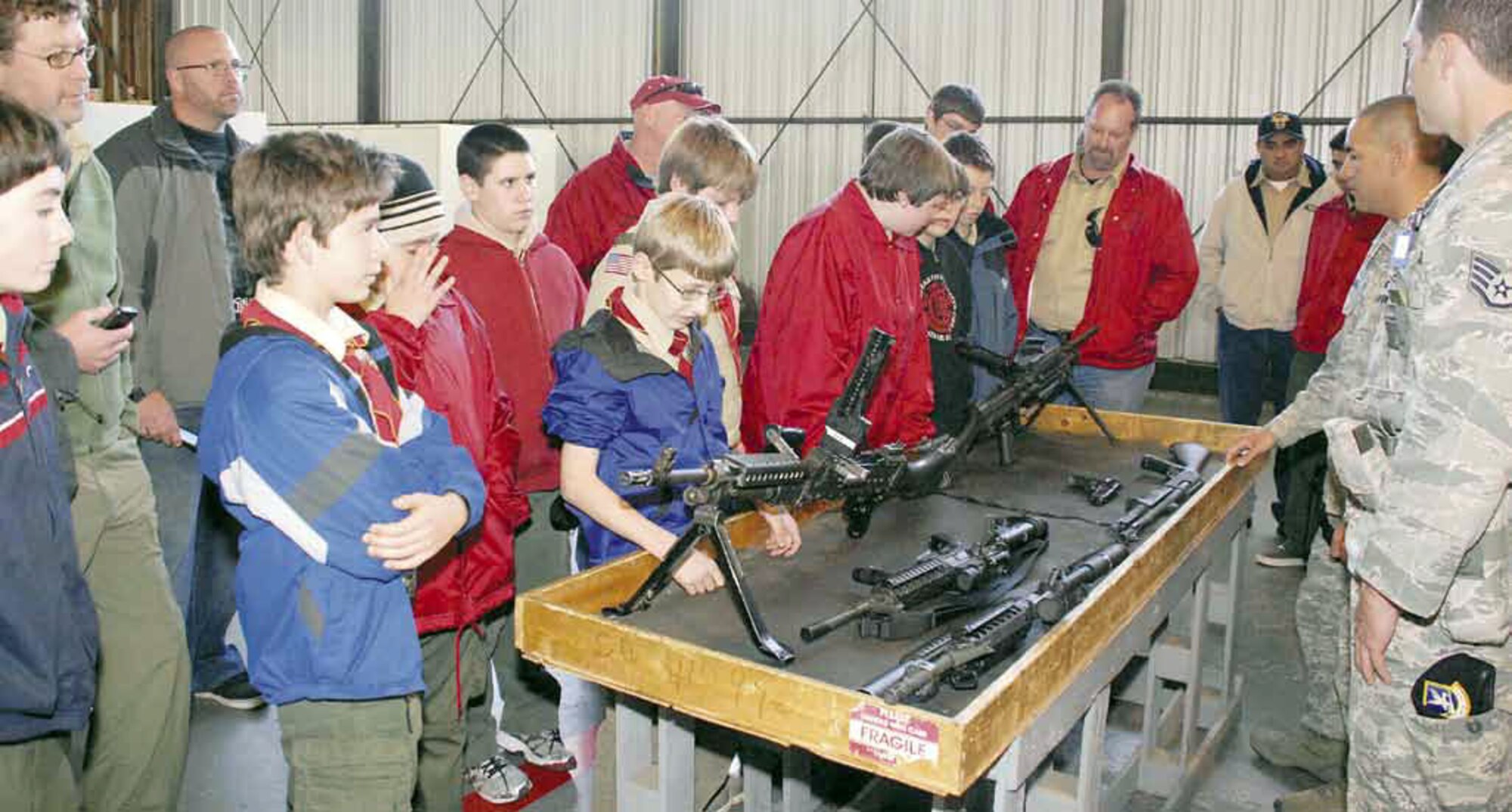 The 452nd Security Forces Airmen brief Boy Scout Troop 270, from Riverside, Calif., on military weapons used in the line of duty. The hands-on demonstration and briefing was part of a March Air Reserve Base Tour provided to Troop 270 on Sat., Jan. 21, which also included C-17 and KC-135 static displays. (U.S. Air Force photo/ Senior Airman Patrick Cabellon)