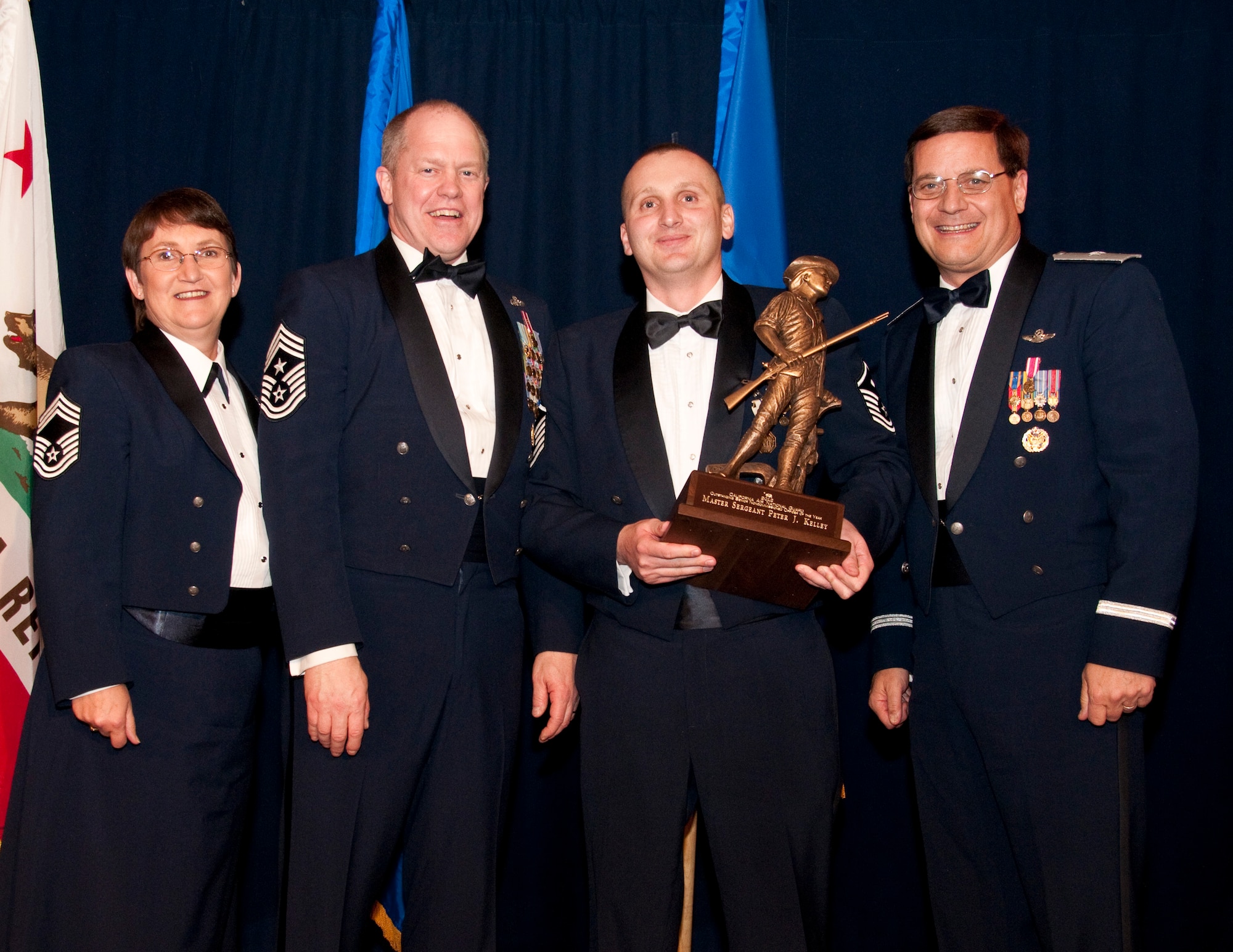 1st Sergeant Ronald Hazelton (center) from the 162rd Combat Communications Group accepts the Outstanding Airman of the Year award in the 1stSgt category. Accompanied by Chief Master Sgt. Debra Fordyce, (far left) Command Chief Master Sgt. Christopher Muncy, (left) and Brigadier General James Witham at the  annual Outstanding Airmen Of The Year Awards Banquet at The Sheraton Universal Hotel, Universal City, Calif.,  January 21, 2012. Each organization nominated four candidates for Airman of The Year, NCO of The Year, Sr. NCO of The Year and First Sergeant of The Year. U.S. Air Force photo by Tech. Sgt. Alex Koenig
