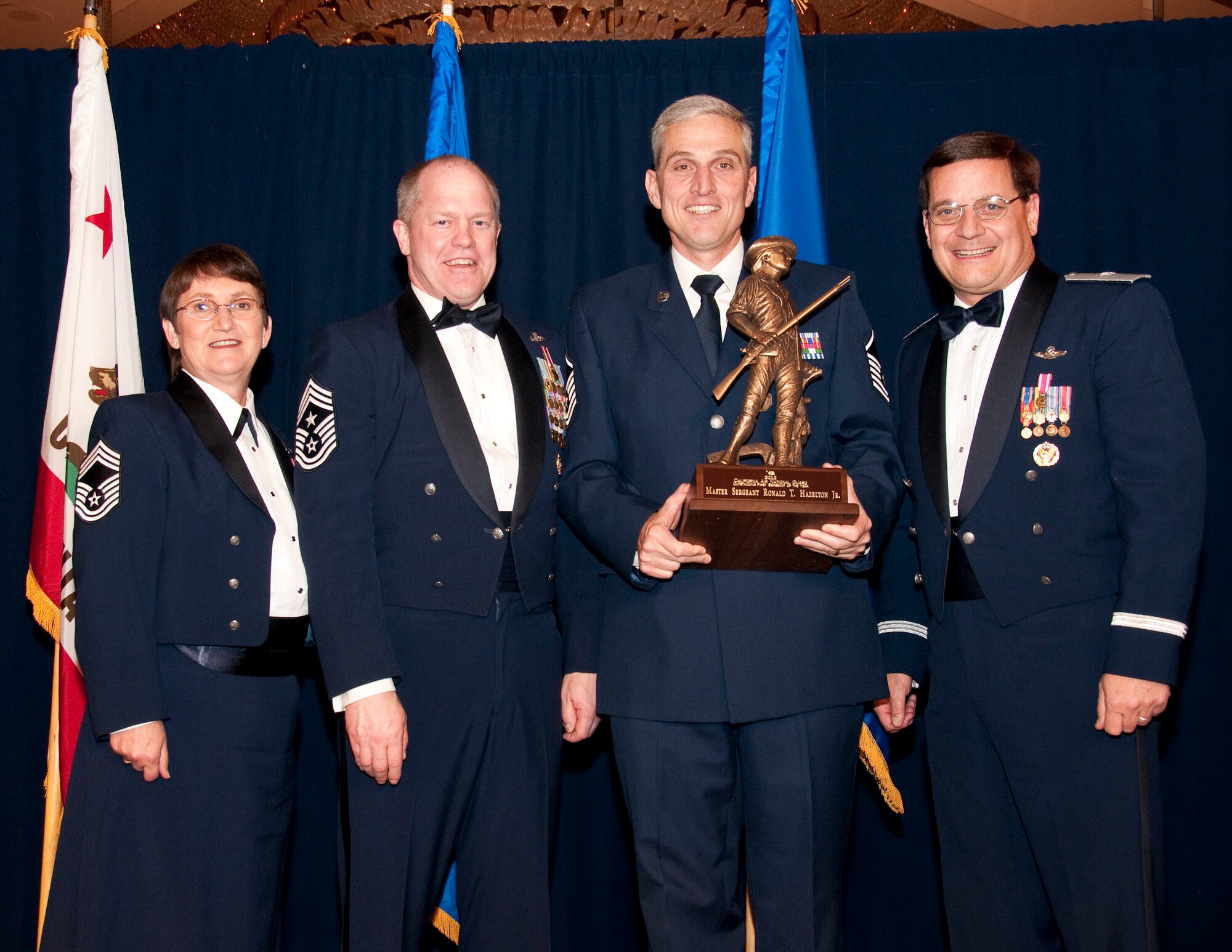 Master Sergeant Peter Kelley (center) from the 163rd Reconnaissance Wing  accepts the Outstanding Airman of the Year award in the Senior NCO category. Accompanied by Chief Master Sgt. Debra Fordyce, (far left) Command Chief Master Sgt. Christopher Muncy, (left) and Brigadier General James Witham at the annual Outstanding Airman Of The Year Awards Banquet at The Sheraton Universal Hotel, Universal City, Calif., January 21, 2012. Each organization nominated four candidates for Airman of The Year, NCO of The Year, Sr. NCO of The Year and First Sergeant of The Year. U.S. Air Force photo by Tech. Sgt. Alex Koenig
