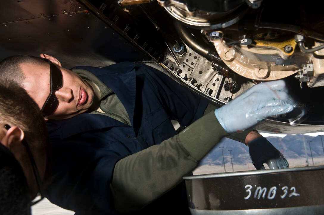 U.S. Air Force Staff Sgt. Jonathon Hill, 28th Aircraft Maintenance Squadron aerospace propulsion journeyman, Ellsworth Air Force Base, S.D., tries to cease a hydraulic pump underneath a B-1B Lancer during Red Flag 12-2 Jan. 24, 2012, at Nellis AFB, Nev. Red Flag is a realistic combat training exercise involving the air forces of the United States and its allies. The exercise is hosted north of Las Vegas on the Nevada Test and Training Range. (U.S. Air Force photo by Senior Airman Brett Clashman)