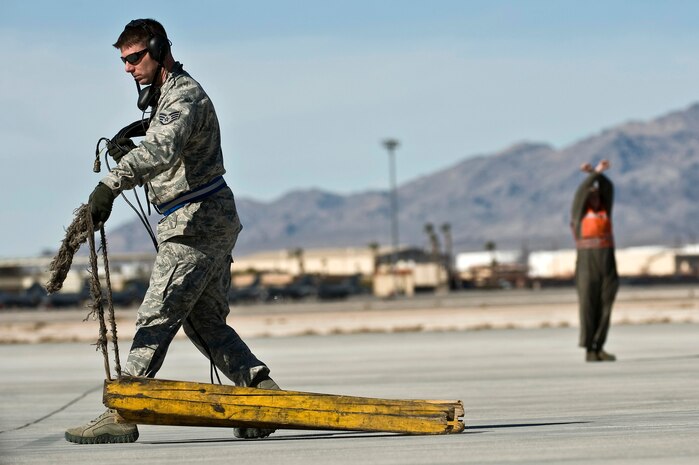 U.S. Air Force Staff Sgt. Joseph Severyn, 28th Aircraft Maintenance Squadron crew chief, Ellsworth Air Force Base, S.D., pulls chaulks away from a B-1B Lancer during Red Flag 12-2 Jan. 24, 2012, at Nellis AFB, Nev. Red Flag is a realistic combat training exercise involving the air forces of the United States and its allies. The exercise is hosted north of Las Vegas on the Nevada Test and Training Range. (U.S. Air Force photo by Senior Airman Brett Clashman)

