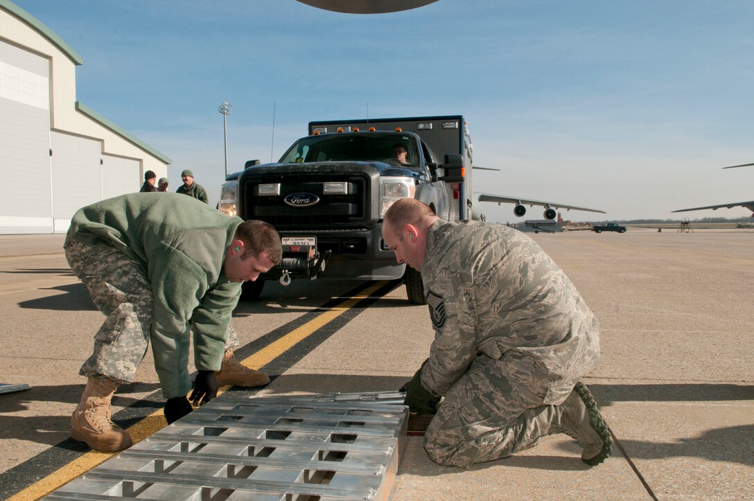 Staff Sgt. Jason Williams, a member of the West Virginia National Guard's 35th Civil Support Team, and Master Sgt. Scott Nye, a loadmaster with the 167th Airlift Wing, adjust a ramp system attached to a C-5 aircraft at the Martinsburg West Virginia Air National Guard unit, Martinsburg, WV,  January 25, 2012. The 35th CST staged in the Eastern Panhandle of West Virginia during the State of the Union Address on January 24, 2012. The following day the team convoyed to the 167th Airlift Wing to test load their newest vehicles onto a C-5 aircraft. (U.S. Air Force photo by Master Sgt. Emily Beightol-Deyerle)