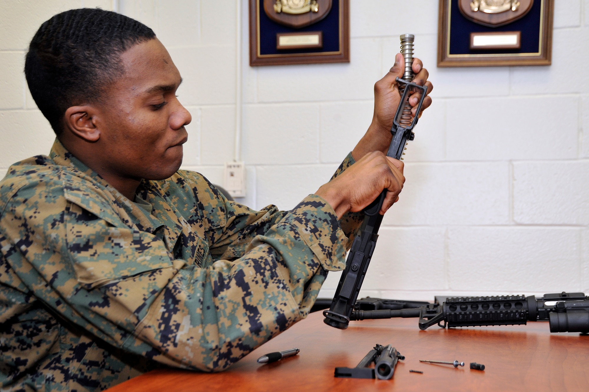 Marine Lance Cpl. Jean Baptiste Henry, Marine Transport Squadron operations technician, field strips an M4 rifle during his Lance Corporal’s Course here, Jan. 10. The course provides training in drill, Marine Corps history, codes of conduct, mentorship and many other classes geared toward improving the Marines before they take on the responsibility of becoming NCOs. (U.S. Air Force Photo/Senior Airman Perry Aston)