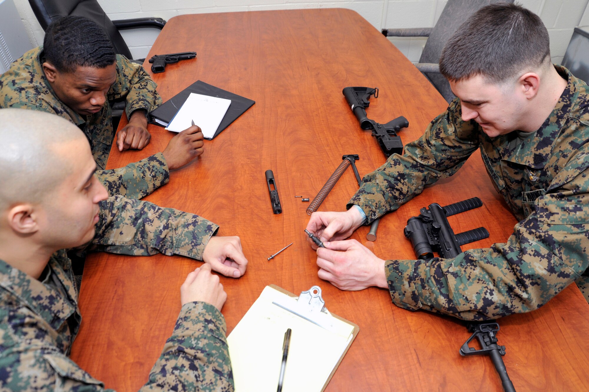 Marine Sergeant Daniel Bason, Marine Transport Squadron Andrews operations chief, refreshes Lance Corporals Samael J. FanesteEspina and Jean Baptiste Henry, Marine Transport Squadron Andrews operations technicians, on how to field strip the M4 carbine rifle during their Lance Corporal’s Course here, Jan. 10. The course provides training in drill, Marine Corps history, codes of conduct, mentorship and many other classes geared toward improving the Marines before they take on the responsibility of becoming NCOs. (U.S. Air Force Photo/Senior Airman Perry Aston)