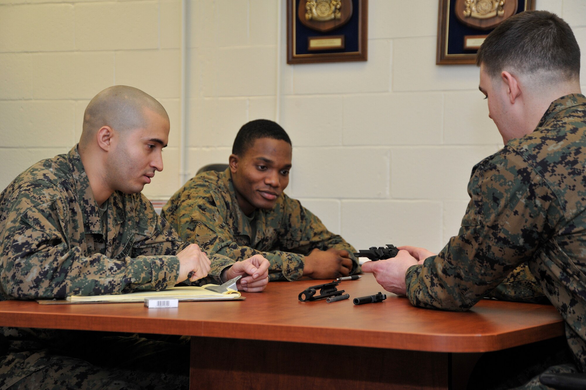 Marine Sergeant Daniel Bason, Marine Transport Squadron Andrews operations chief, refreshes Lance Corporals Samael J. FanesteEspina, and Jean Baptiste Henry, Marine Transport Squadron Andrews operations technicians, on how to field strip the Beretta M9 during their Lance Corporal’s Course here, Jan. 10. The course provides training in drill, Marine Corps history, codes of conduct, mentorship and many other classes geared toward improving the Marines before they take on the responsibility of becoming NCOs. (U.S. Air Force Photo/Senior Airman Perry Aston)