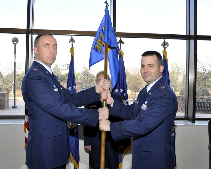 PETERSON AIR FORCE BASE, Colo.- Capt. Brian Young assumed command of the 302nd Security Forces Squadron in an assumption of command ceremony held here, Jan. 8. On left Col. Michael Burns, 302nd Mission Support Group Commander passes the 302nd SFS guidon to Capt. Brian Young. (U.S. Air Force photo/Tech. Sgt. Peter Dean)