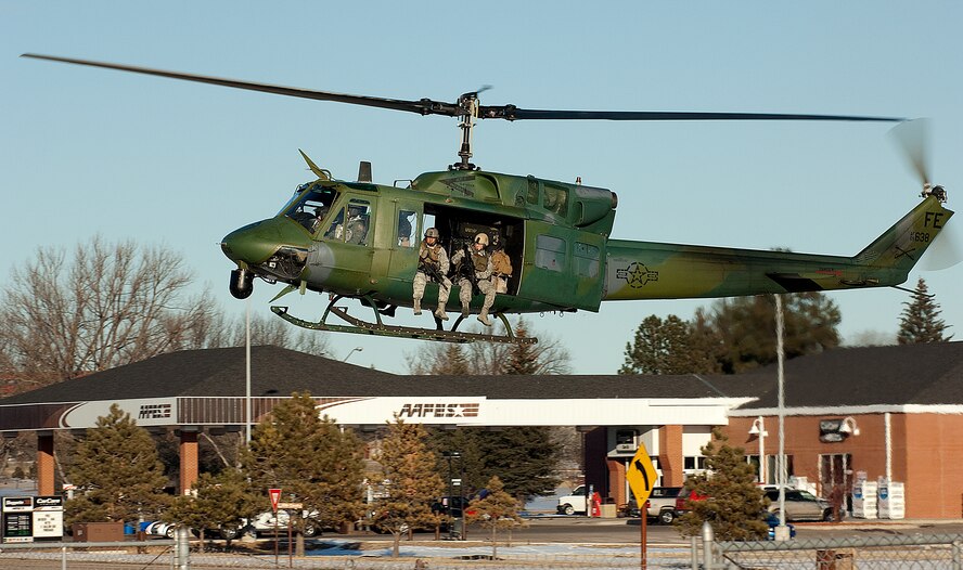 Members of the 90th Security Forces Group prepare to jump out of an UH-1N Huey helicopter, piloted by 37th Helicopter Squadron members during a recent exercise here. (U.S. Air Force photo by R.J. Oriez)