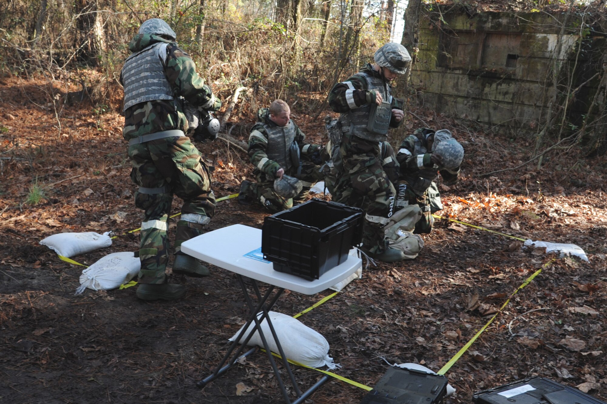 Airmen from the 4th Civil Engineer Squadron run into a simulated bunker and prepare to don their protective masks during Ability to Survive and Operate Rodeo training on Seymour Johnson Air Force Base, N.C., Jan. 25, 2012. During simulated alarm red, Airmen have two minutes to change into Mission Oriented Protective Posture 4 gear which will protect them from a chemical attack. (U.S. Air Force photo/Senior Airman Whitney Stanfield)  