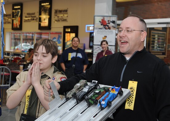 RAF MILDENHALL, ENGLAND – Capt. Matthew Addison, 352nd Special Operation Support Squadron, counts down as he prepares to release cars during the Pinewood Derby at the Exchange here Jan. 21, 2012.  The event is held annually by Pack 215 of the Boy Scouts of America and challenges scouts at the base to build and race their own cars. (U.S. Air Force photo by Tech. Sgt. Neal Joiner)