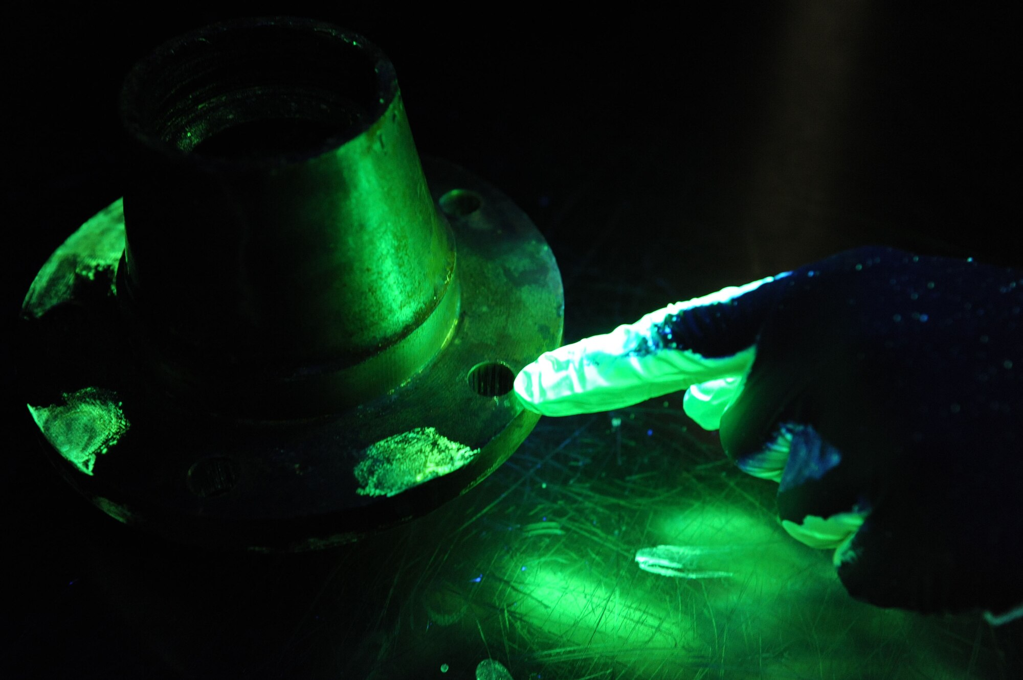 SPANGDAHLEM AIR BASE, Germany – Senior Airman Sal Turner, 52nd Equipment Maintenance Squadron non destructive inspection journeyman, points to an aircraft part crack found during a florescent penetrant inspection here Jan. 25. NDI Airmen inspect aircraft and support equipment to check for minute crack defects and as required per technical order. The NDI lab provides effective test methods to examine the structural integrity of an object or material so the 52nd Fighter Wing can accomplish its flying mission. (U.S. Air Force photo/Senior Airman Christopher Toon)