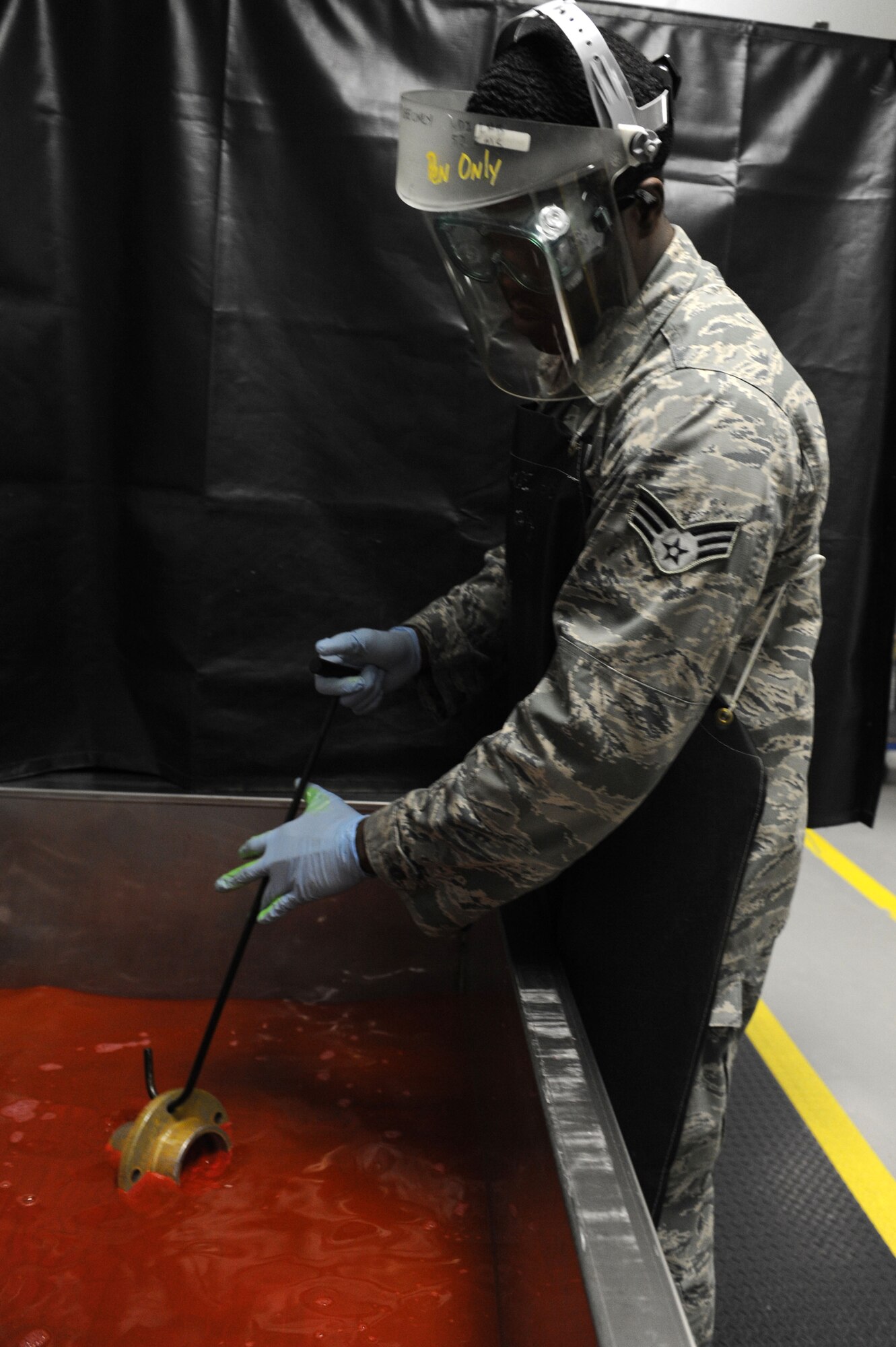 SPANGDAHLEM AIR BASE, Germany – Senior Airman Sal Turner, 52nd Equipment Maintenance Squadron non destructive inspection journeyman, dips an aircraft part in hydrophilic remover during the removal process of a florescent penetrant required for inspection here Jan. 25. NDI Airmen inspect aircraft and support equipment for minute crack defects and as required per technical order. The NDI lab provides test methods to examine the structural integrity of an object or material so the 52nd Fighter Wing can accomplish its flying mission. (U.S. Air Force photo/Senior Airman Christopher Toon)