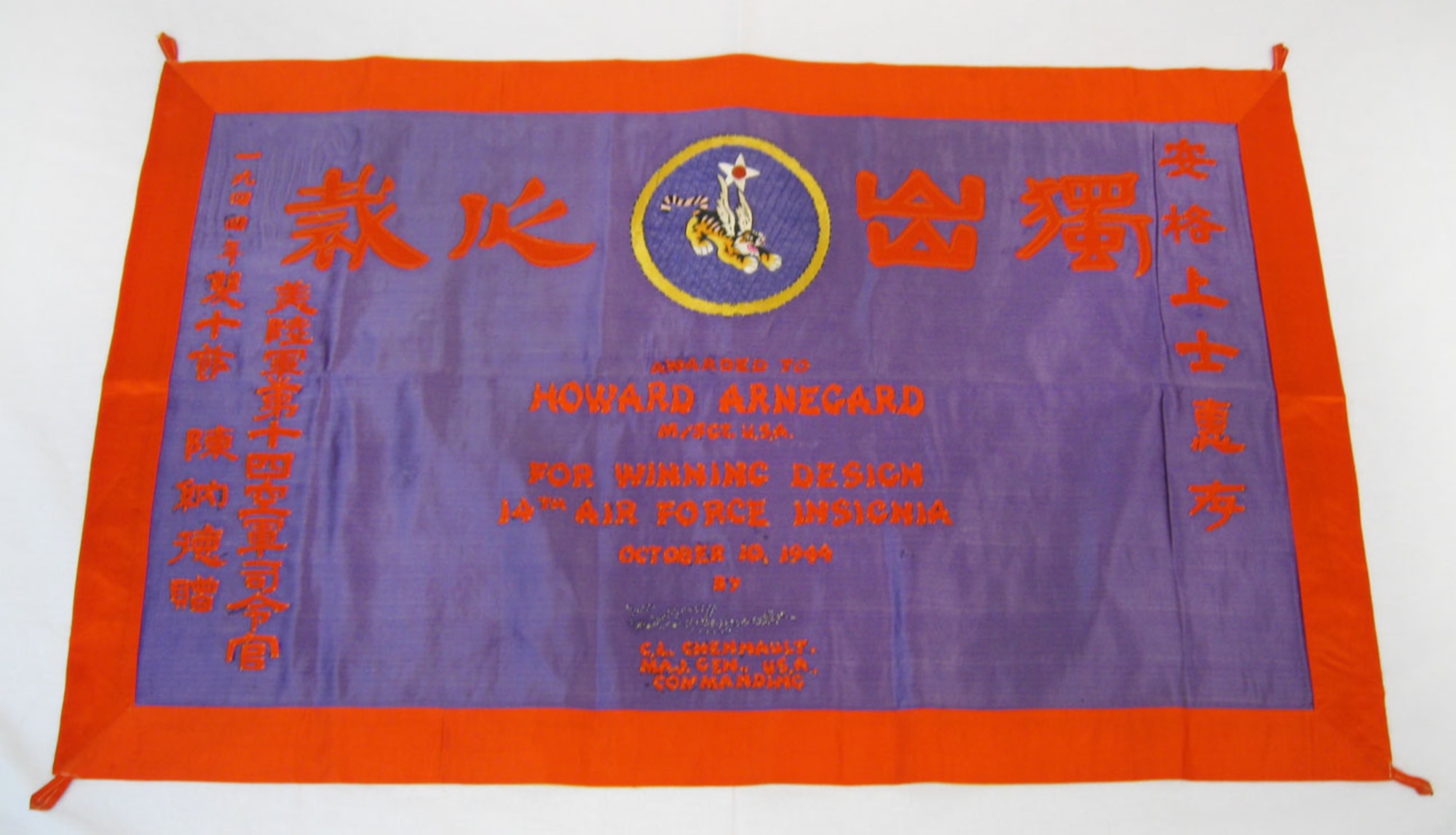 This banner was awarded to the donor's father, Howard Arnegard, for the winning design in Maj. Gen. Claire Chennault's contest for the 14th Air Force insignia. It was made in 1944 in China. The Chinese lettering translates to the English wording on the banner. (U.S. Air Force photo)