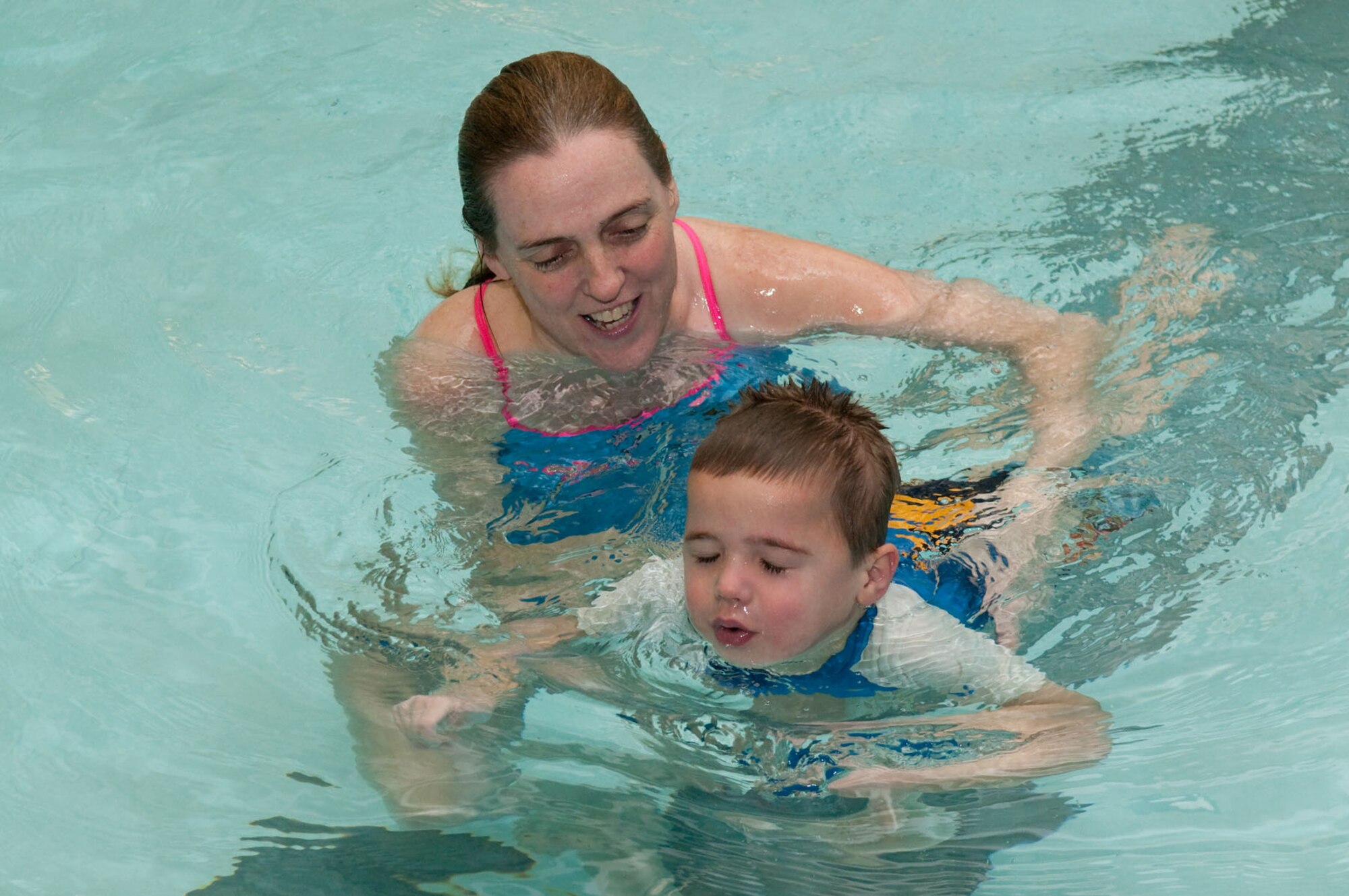 HANSCOM AIR FORCE BASE, Mass. - Mary McCusker, an instructor at the base swimming pool, shows Colby Hiott how to swim while kicking his legs during a lesson Jan. 19. Swimming lessons are offered to all military ID card holders, DoD civilians and contractors. Contact the pool at 781-225-6638 for more details. (U.S. Air Force photo by Mark Herlihy)