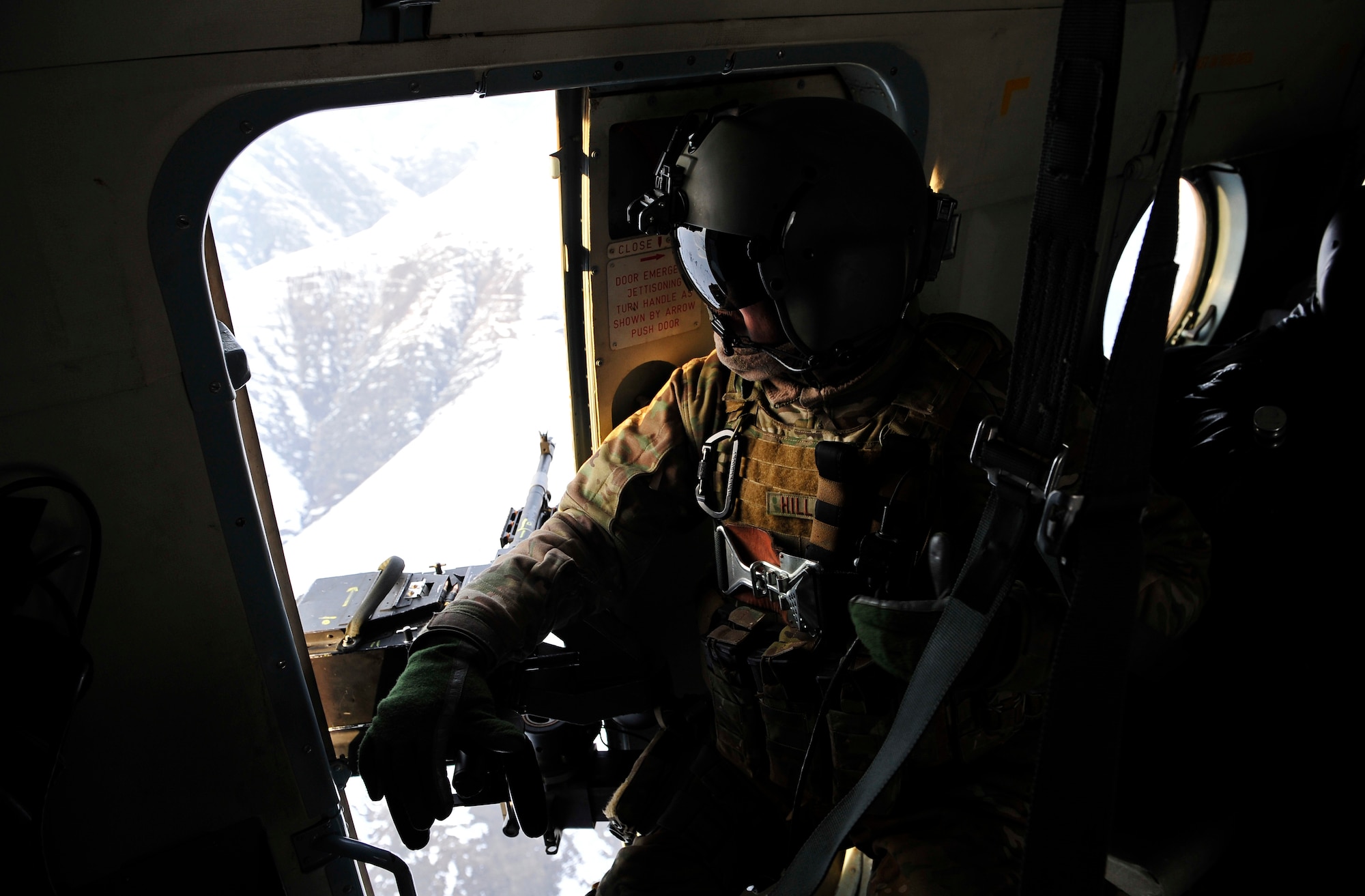 Staff Sgt. Jonathan Hill, an Mi-17 helicopter engineer from the 438th Air Expeditionary Advisory Squadron, scans from his helicopter as it flies a rescue mission Jan 24, 2012. American and Afghan Airmen conducted a rescue mission in Badakshan province, Afghanistan after an avalanche trapped and injured members of Shewa Village. (U.S. Air Force photo/ Master Sgt. Shane A. Cuomo)