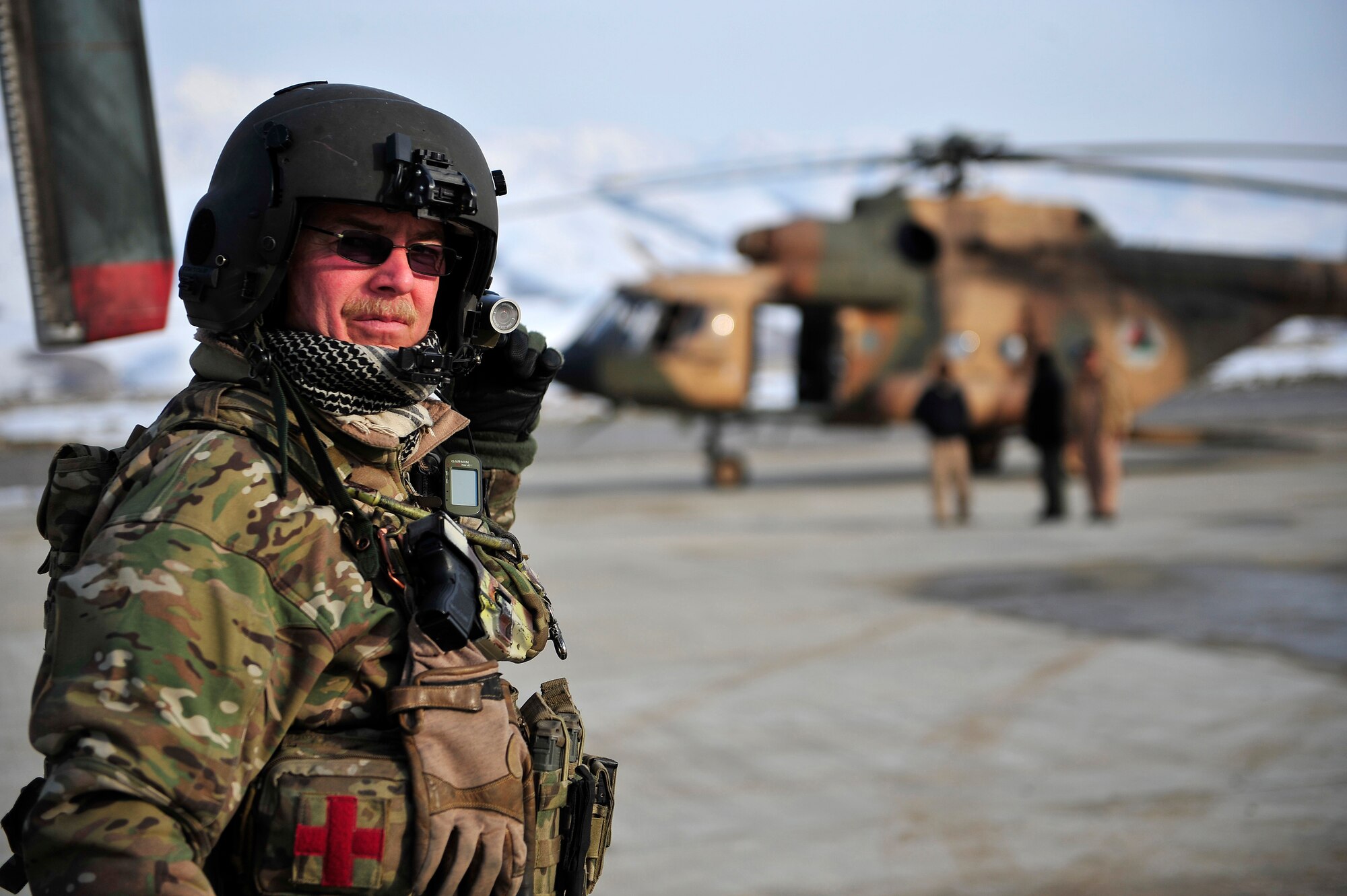 Senior Master Sgt. Todd Peplow, an Mi-17 helicopter gunner from the 438th Air Expeditionary Advisory Squadron, waits as injured villagers are carried off his Mi-17 helicopter to awaiting ambulances at Fayzabad, Afghanistan Jan 24, 2012. American and Afghan Airmen conducted a rescue mission in Badakshan province, after an avalanche trapped and injured members of Shewa Village. (U.S. Air Force photo/ Master Sgt. Shane A. Cuomo)


