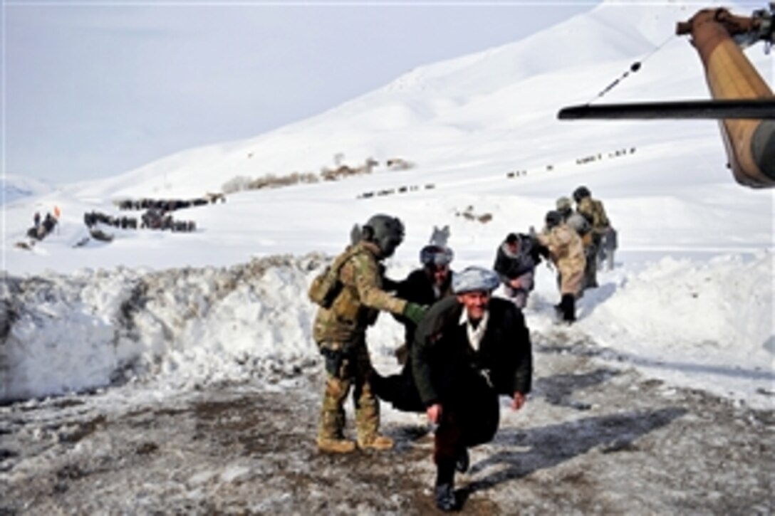 U.S. Air Force Staff Sgt. Jonathan Hill, left, directs villagers to his Mi-17 helicopter in Shewa village in Afghanistan's Badakhshan province, Jan. 24, 2012. Hill is an Mi-17 helicopter engineer assigned to the 438th Air Expeditionary Advisory Squadron.