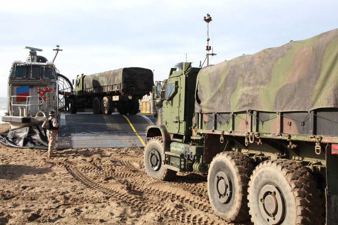 Marines from Combat Logistics Battalion 15, 1st Marine Logistics Group, drive two 7-ton trucks aboard a Landing Craft Air Cushion during a familiarization exercise at Camp Pendleton, Calif., Jan. 24. The event was part of Exercise Iron Fist 2012, a bilateral amphibious training exercise between U.S. Marines and the Japanese Ground Self Defense Force.