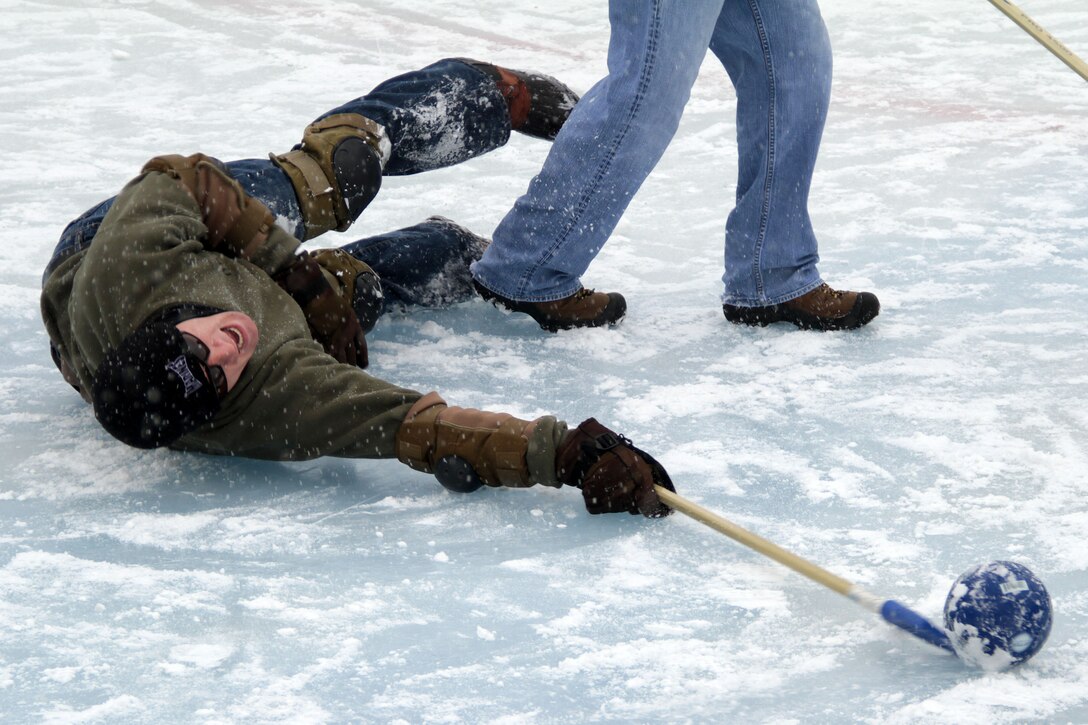 Sgt. Brandon Blazer, Recruiting Substation Woodbury, tries to pass a loose ball before an opponent can snatch it up during the 2012 Recruiting Station Twin Cities broom ball tournament Jan. 27. For additional imagery from the event, visit www.facebook.com/rstwincities.