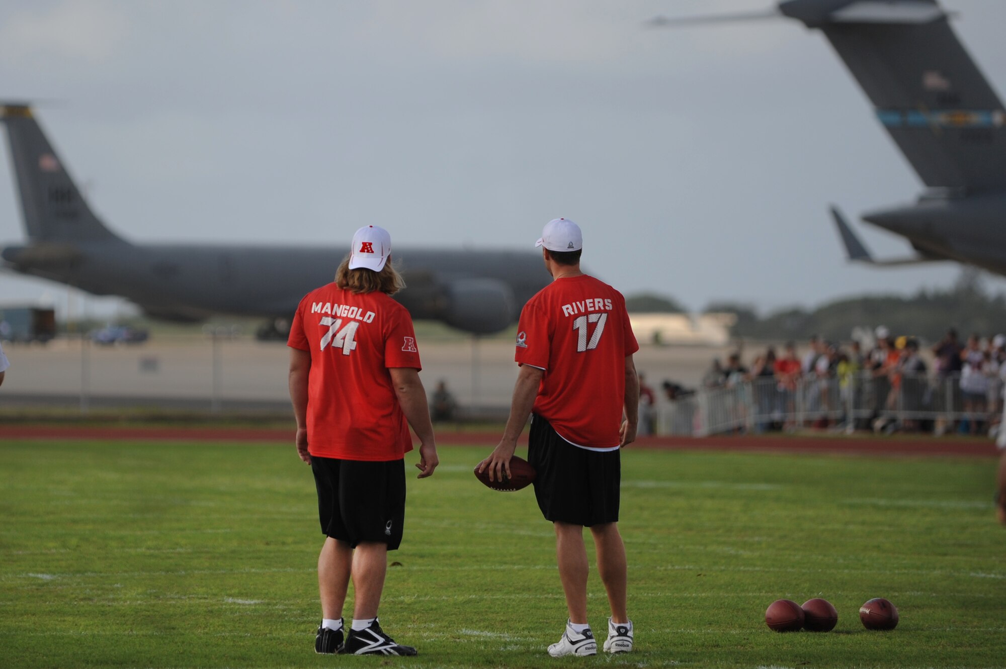 Nick Mangold, New York Jets center, and Philip Rivers, San Diego Chargers quarterback, take a moment during AFC Pro Bowl practice session warm-ups to gaze at the Air Force C-17 Globemaster III, the KC-135 Stratotanker and the C-5 Galaxy overlooking Earhart Field at Joint Base Pearl Harbor-Hickam, Hawaii, Jan. 26. The National Football League Network filmed their Pro Bowl practice coverage from the field during the practices and filmed the players interacting with servicemembers and their families. (U.S. Air Force photo/Staff Sgt. Mike Meares)