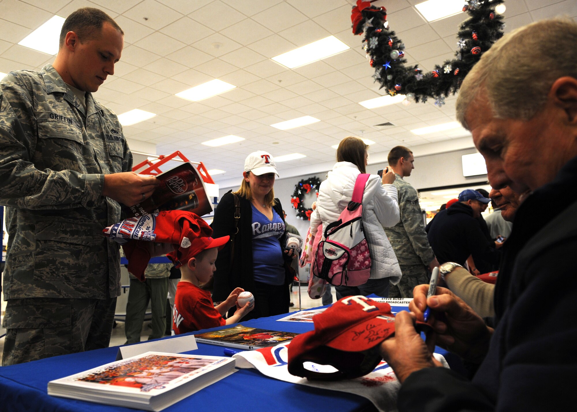 Texas Rangers’ Jackie Moore, bench coach, signs a hat for U.S. Air Force Tech. Sgt. Benjamin Griffin, 317th Maintenance Operations Squadron, during a base tours, Jan. 25, 2012, at Dyess Air Force Base. The Rangers visit multiple bases in Texas annually to sign autographs and meet military personnel. (U.S. Air Force photo by Airman 1st Class Jonathan Stefanko/Released)