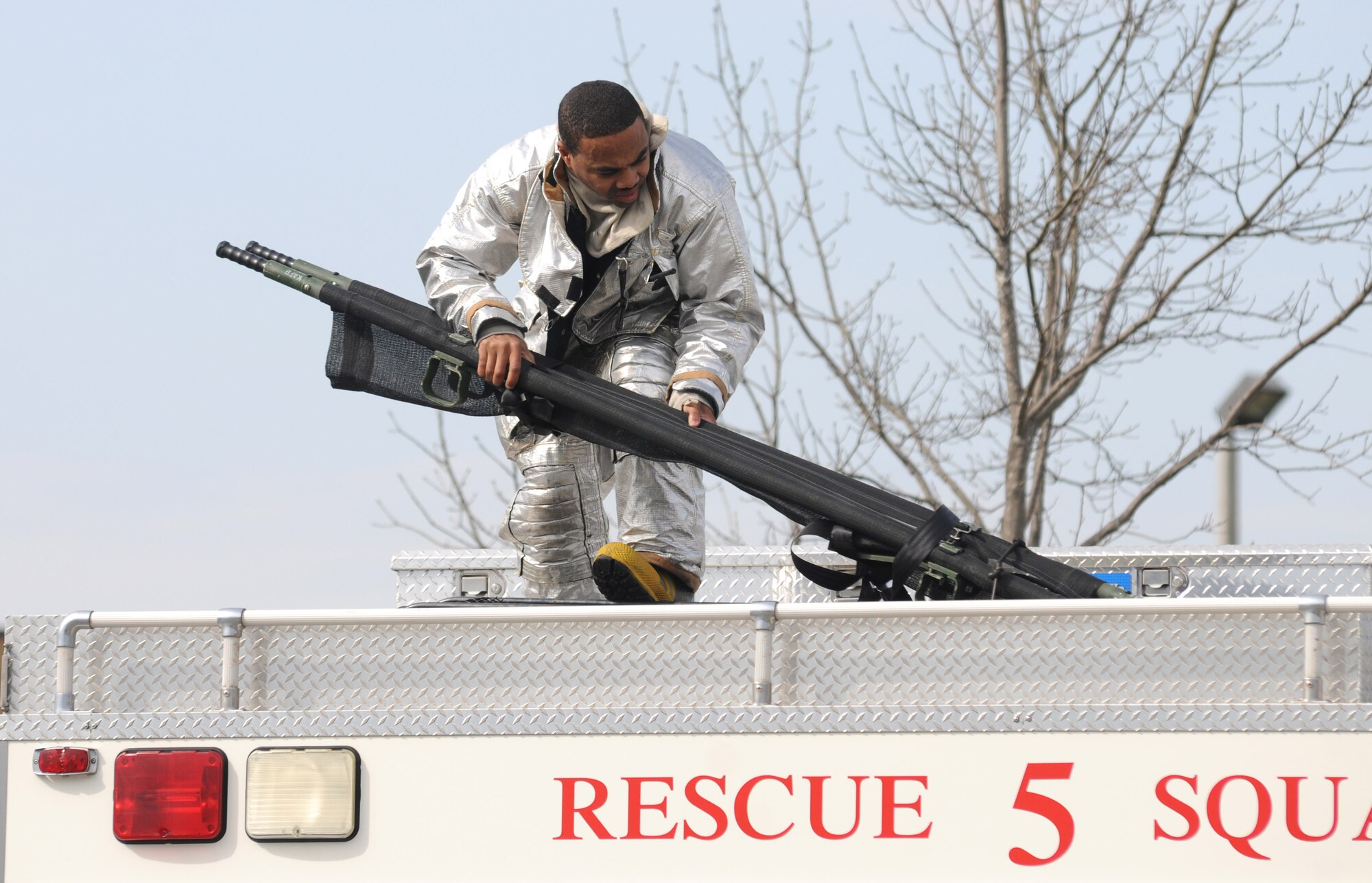 John McIntyre, Keesler Fire Department, deploys equipment from a fire truck to be used at the site of a Chemical, Biological, Radiological, Nuclear, and high-yield Explosive exercise scenario Jan. 26, 2012, at Keesler Air Force Base, Miss. The Force Protection Condition exercise scenario included a terrorist group that was able to penetrate the base and park a truck with a four, hundred-gallon barrels full of anhydrous ammonia by the soccer field on G Street.  A small improvised explosive device was “exploded” causing the anhydrous ammonia to pour from the trailer, exposing a group of ten Airmen who had just finished physical training.  Immediately the Airmen simulated receiving skin and eye irritations and burns, coughing, chest pain and vomiting from exposure to the chemical.  Two Airmen also simulated receiving broken bones from flying debris from the explosion.   Also the 81st Medical Group and 81st Security Forces Squadron responded on scene.  The exercise took place Jan. 23-27.  (U.S. Air Force photo by Kemberly Groue)
