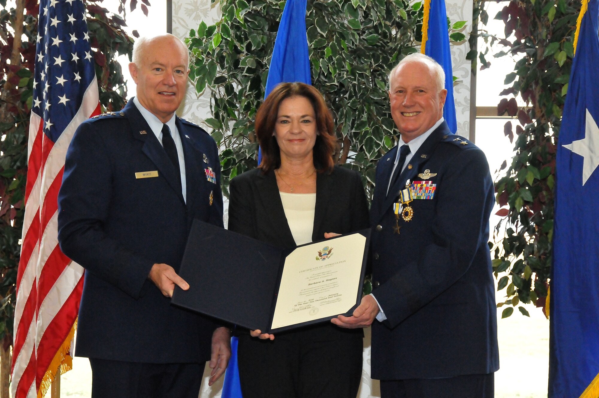 Lt. Gen. Harry M. Wyatt III (left) presents a Certificate of Appreciation to MBarbara Haynes (center) on behalf of the U.S. Air Force thanking her for her commitment and contributions during the career of her spouse, Maj. Gen. Thomas J. Haynes (right), Air National Guard Assistant to the Commander, Air Mobility Command, during Haynes' retirement ceremony at Scott Air Force Base, Ill., on Jan. 27, 2012.