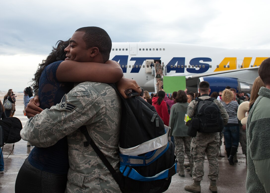 Senior Airman James Taylor, 28th Aircraft Maintenance Squadron weapons journeyman, embraces Senior Airman Ebony Nelson, Air Force Financial Services Center finance technician, during the homecoming event on Ellsworth Air Force Base, S.D., Jan. 25, 2012. Ellsworth Airmen returned from a six-month deployment to Southwest Asia where they were essential in providing critical air presence, surveillance and reconnaissance. (U.S. Air Force photo by Airman Alystria Maurer/Released)
