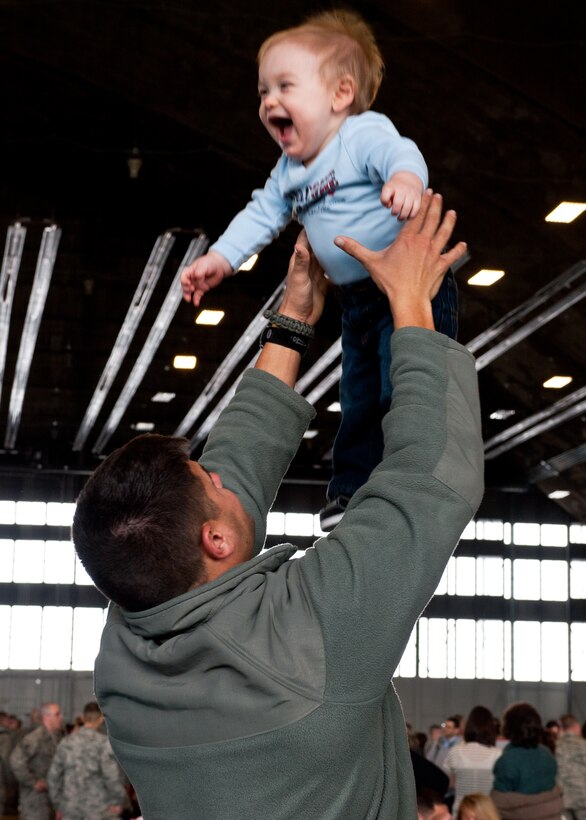 Airman 1st Class Cameron Smith, 28th Munitions Squadron munitions storage crewmember, plays with his son, Elijah, during the homecoming event on Ellsworth Air Force Base, S.D., Jan. 25, 2012. More than 400 Airmen were greeted by their families, friends and colleges after returning from a six-month deployment to Southwest Asia. (U.S. Air Force photo by Airman Alystria Maurer/Released)
