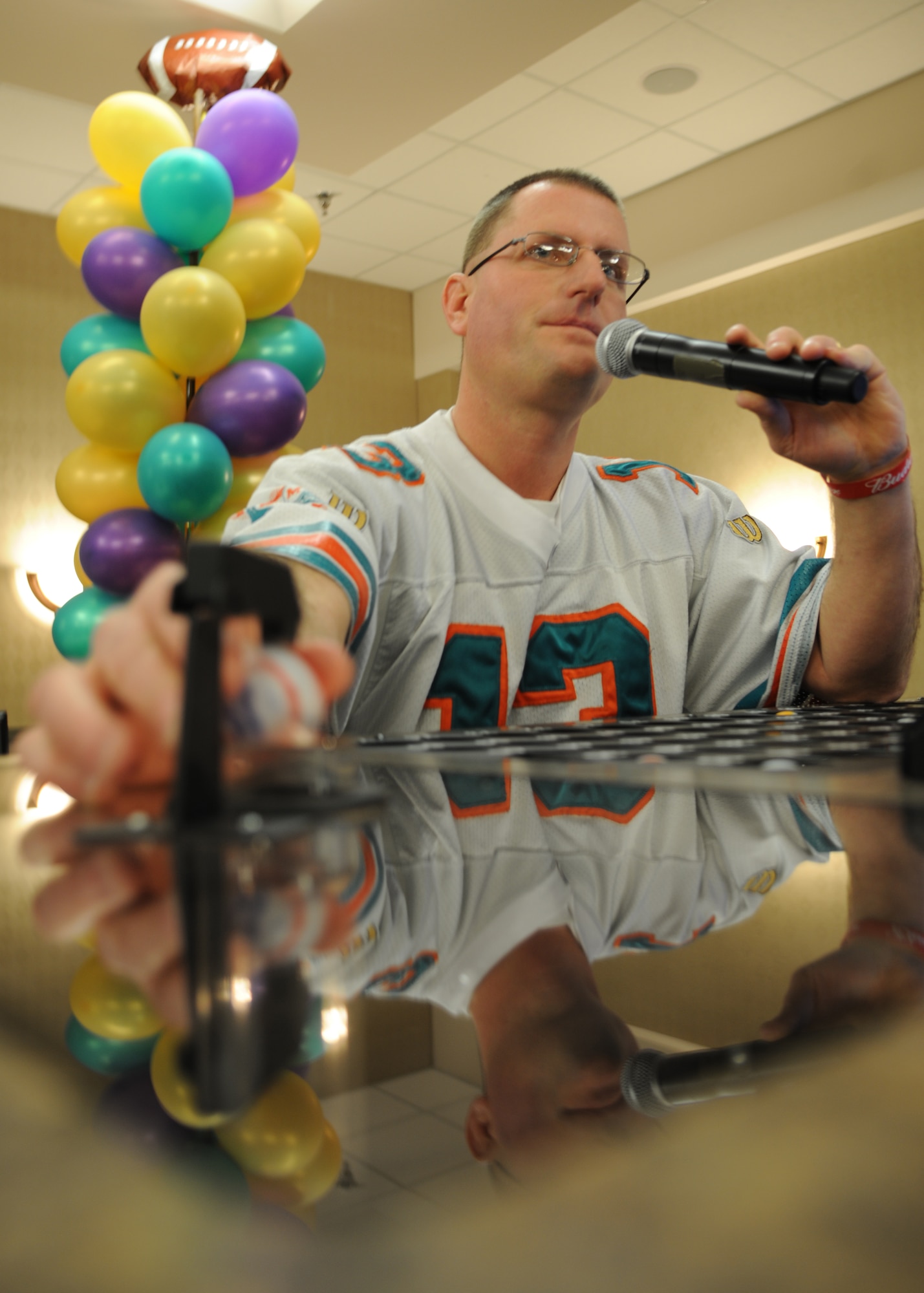 Bingo caller Steve Nosbusch grabs a bingo ball at the 6th annual Super Bowl Extravaganza on Jan. 21, 2012, on Grand Forks Air Force Base, N.D.  The 319th Force Support Squadron hosts the annual SBE to give the Grand Forks military and community members the opportunity to interact and win more than $38,000 in door prizes, including a chance to win a free trip to the Super Bowl or $5,000 cash. (U.S. Air Force photo/Airman 1st Class Ashley N. Taylor)