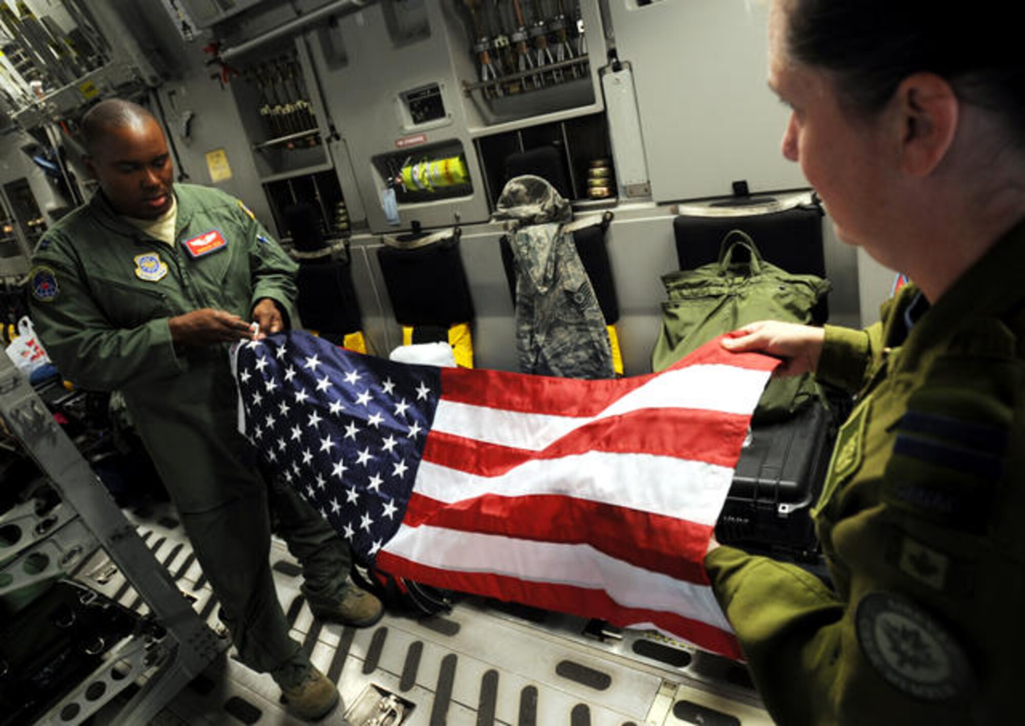 U.S. Air Force Capts. Roderick Reid, center, and Carol Nicholson, both flight nurses from the 775th Expeditionary Aeromedical Evacuation Flight, fold an American flag on a C-17A Globemaster III aircraft June 20, 2010, at Naval Air Station North Island, Calif., during the weekly Integrated Continental United States Medical Operations Plan mission. Service members who participate in the mission pick up war wounded and other patients at Andrews Air Force Base, Calif., and return them to their homes throughout the United States. (U.S. Air Force photo by Master Sgt. Rick Sforza/Released)