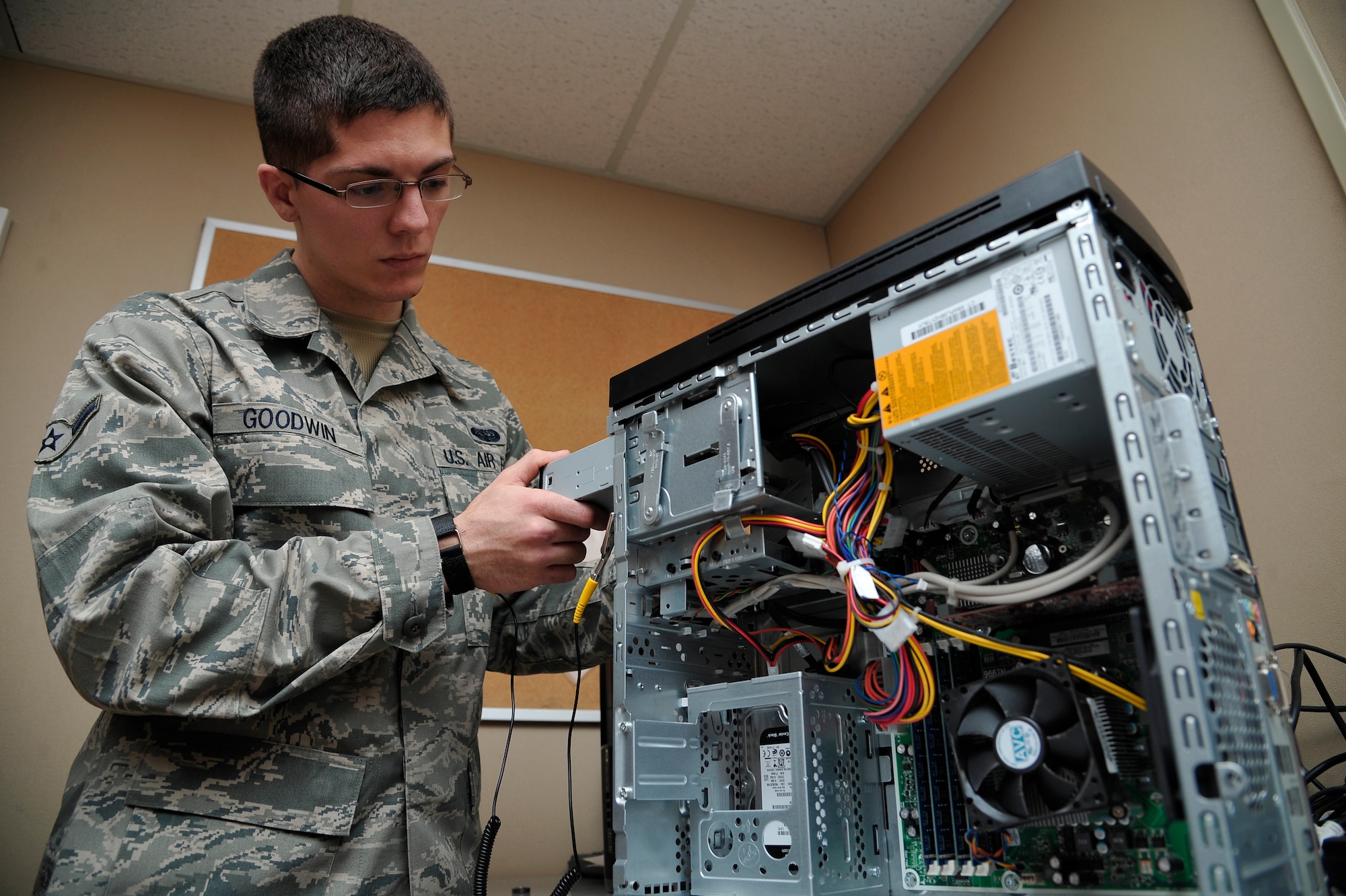 U.S. Air Force Airman Justin Goodwin installs an optical drive on a computer Jan. 26, 2012, Eielson Air Force Base, Alaska. The Network Control Center handles over 90 trouble tickets a week and ensures Eielson is able to meet its mission capabilities by resolving computer issues. Goodwin is a client systems apprentice assigned to the 354th Communications Squadron. (U.S. Air Force photo by Staff Sgt. Christopher Boitz/Released)