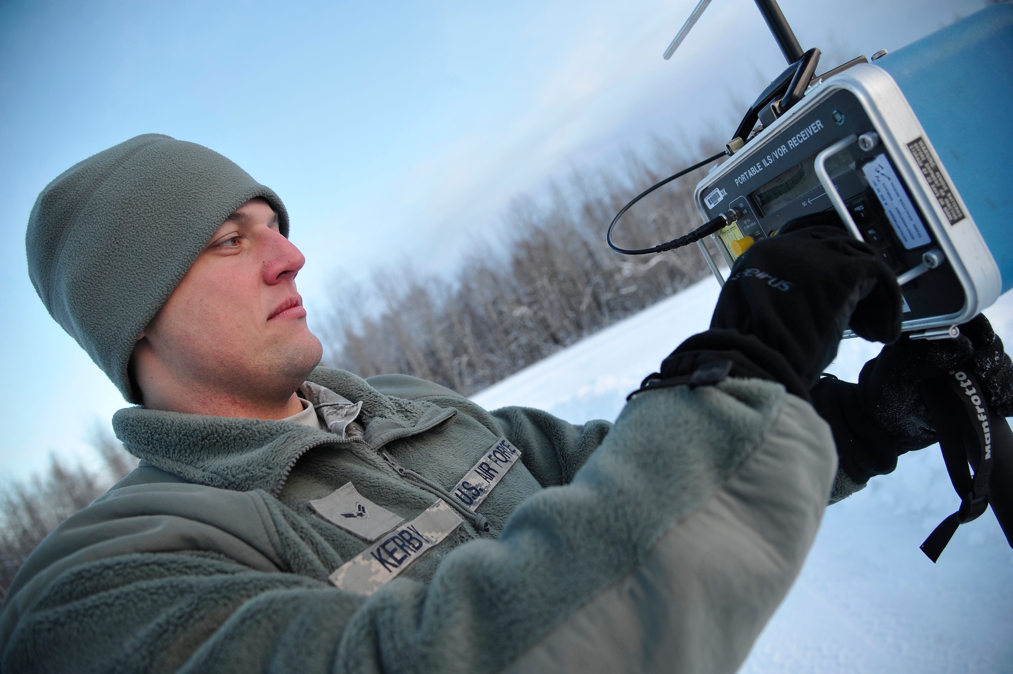 U.S. Air Force Airman 1st Class Michael Kerby uses a portable instrument landing system/VHF omnidirectional range receiver to take readings from runway antennas Jan. 26, 2012, Eielson Air Force Base, Alaska. The receiver ensures antennas are giving proper signal patterns which enable aircraft to land during inclement weather. Kerby is an airfield systems technician assigned to the 354th Communications Squadron. (U.S. Air Force photo by Staff Sgt. Christopher Boitz/Released)