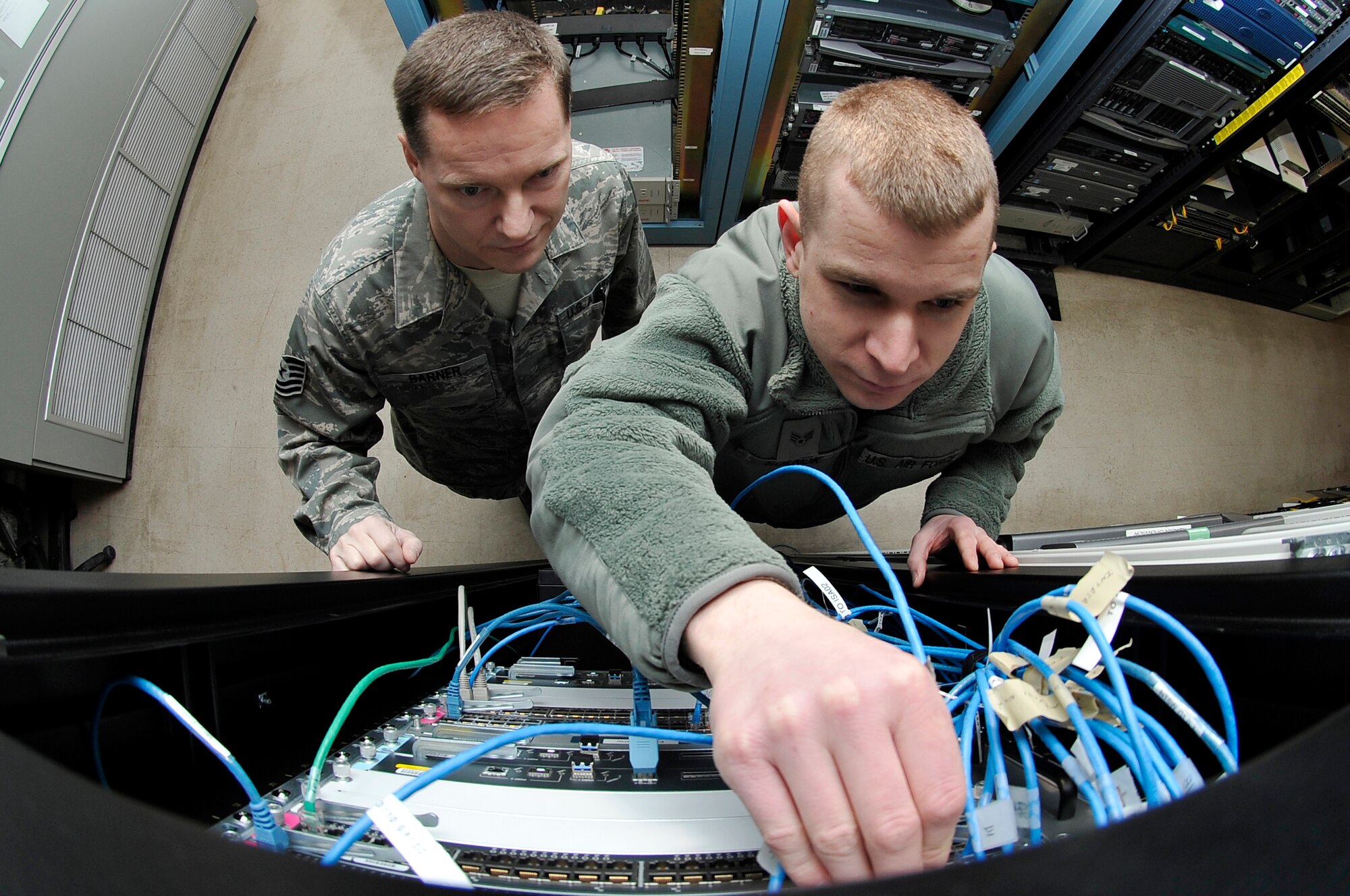U.S. Air Force Tech Sgt. Kevin Garner and Senior Airman David Solnok hook cables in to the new Air Force Network router Jan. 26, 2012, Eielson Air Force Base, Alaska. The AFNet system recently came online at Eielson and has enhanced cyber capabilities by providing network oversight to all USAF installations. Garner and Solnok are cyber transport technicians assigned to the 354th Communications Squadron. (U.S. Air Force photo by Staff Sgt. Christopher Boitz/Released)